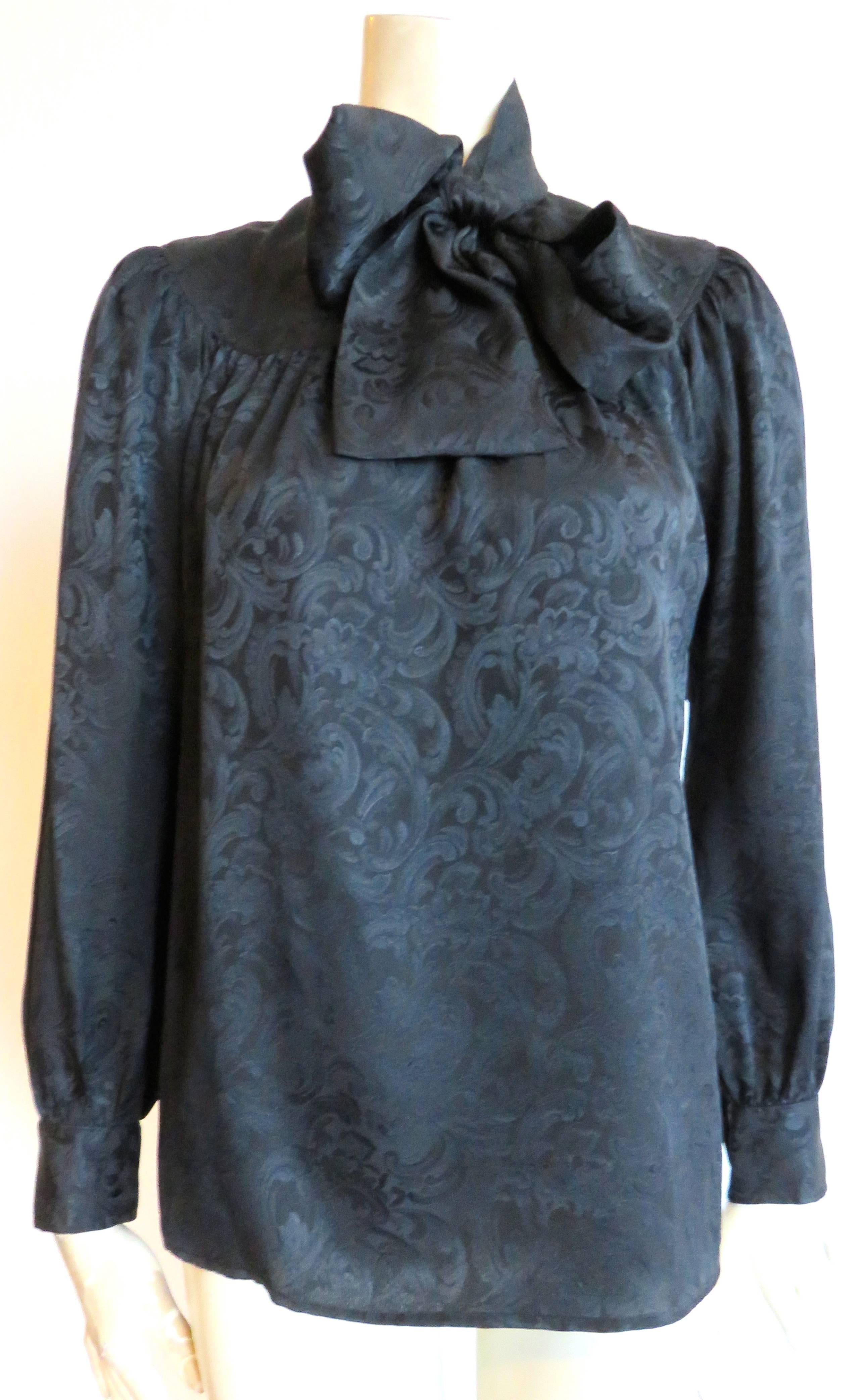 Excellent condition, 1970's YVES SAINT LAURENT, black silk jacquard blouse  with neck-tie detailing.

Single-button, keyhole-style neck opening with smock-style, curved seam construction at top of blouse.  Gathered construction at top