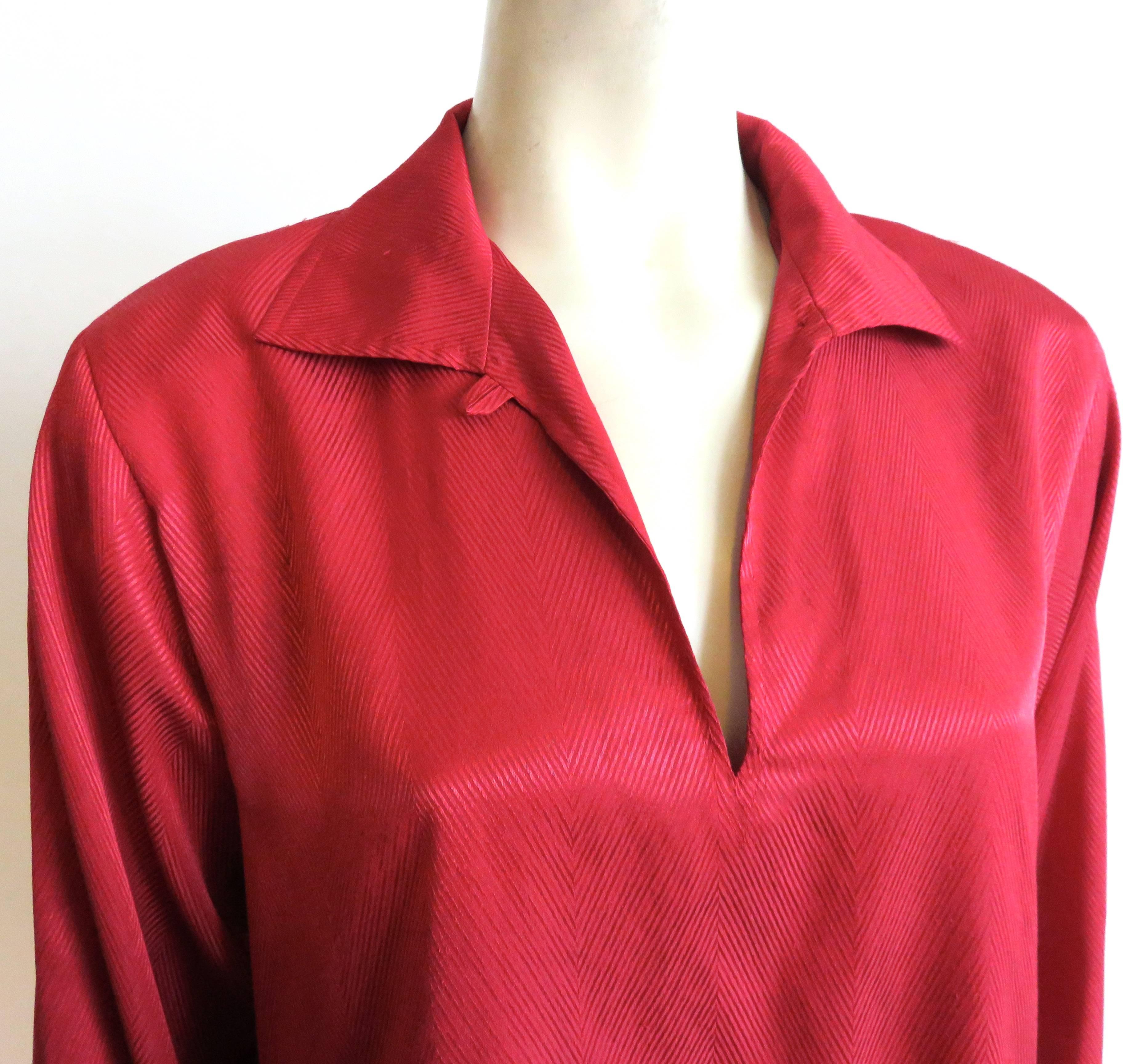 Excellent condition, late 1980's-early 1990's YVES SAINT LAURENT red, silk herringbone jacquard blouse with split neck front opening.

Loose fit silhouette.

*MEASUREMENTS*

There is no size label attached.  We estimate the top to be a US size