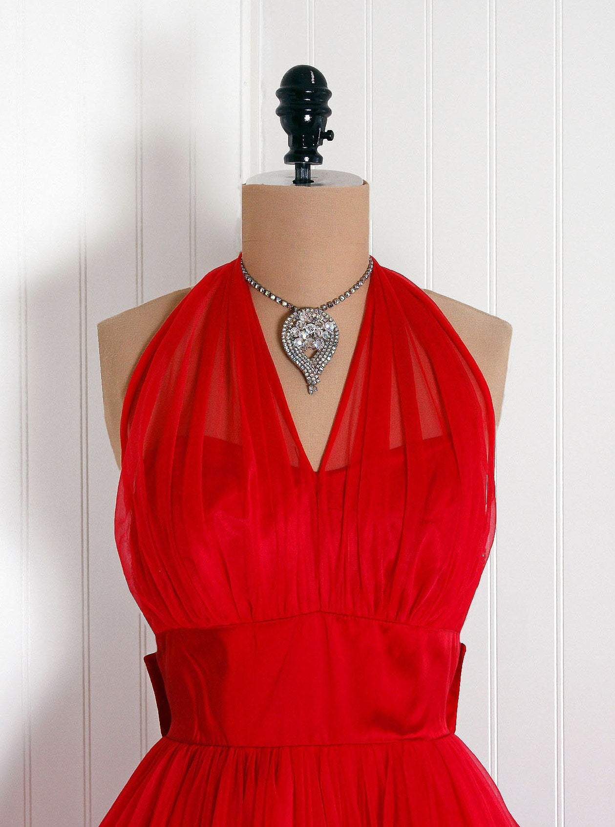 This is one of the most alluring and flattering 1950's party dress I have ever seen! Fashioned from ruby-red chiffon and satin, this creation has everything a woman wants. The bodice is a beautiful sweetheart illusion, low-cut plunge halter. I adore