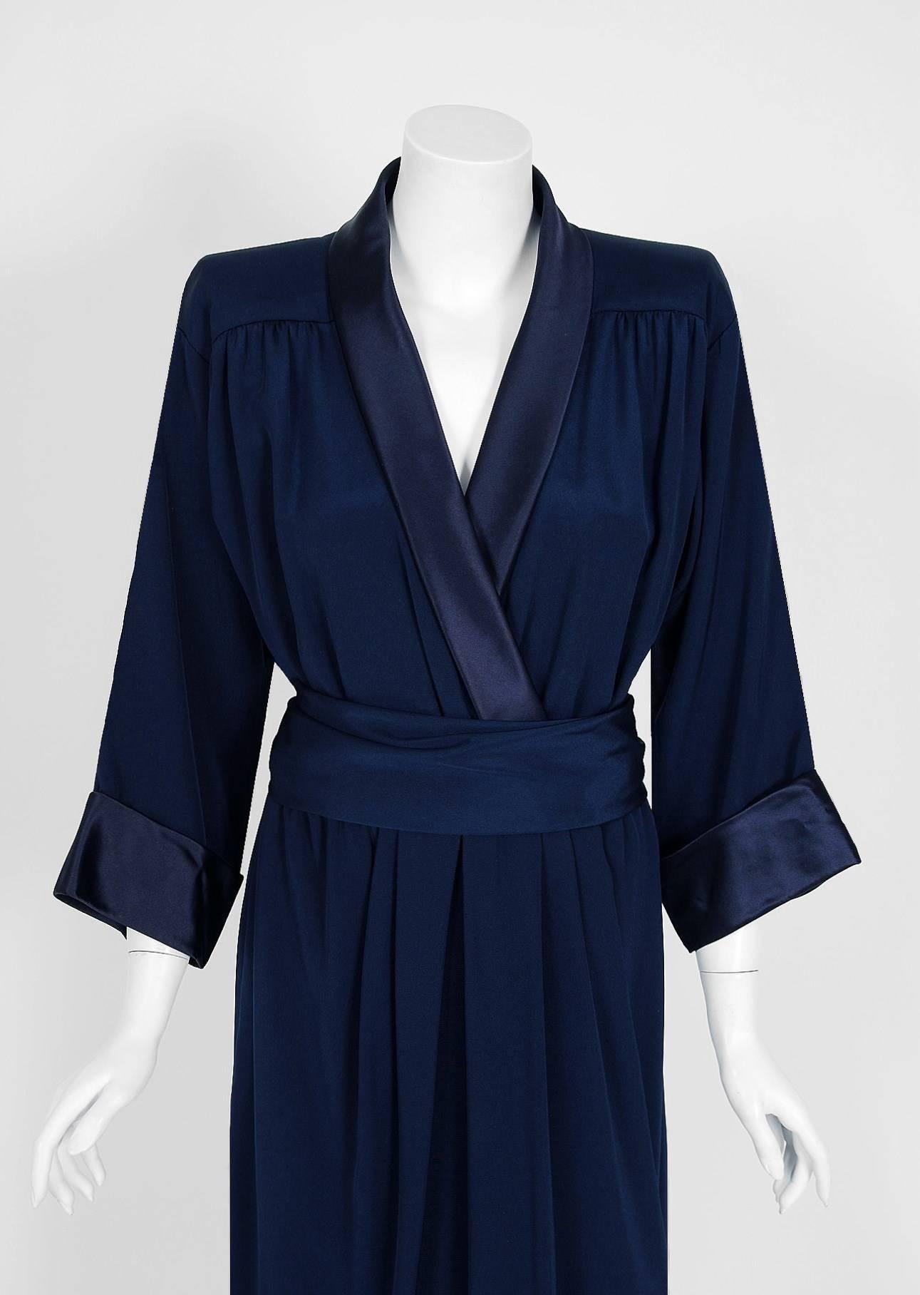 Breathtaking Yves Saint Laurent designer dress from his 1979 collection. Such a rarity to find both pieces together! It is insanely chic with its easy-to-wear wrapped construction. The fabric is a rich navy-blue woven silk complete with liquid satin