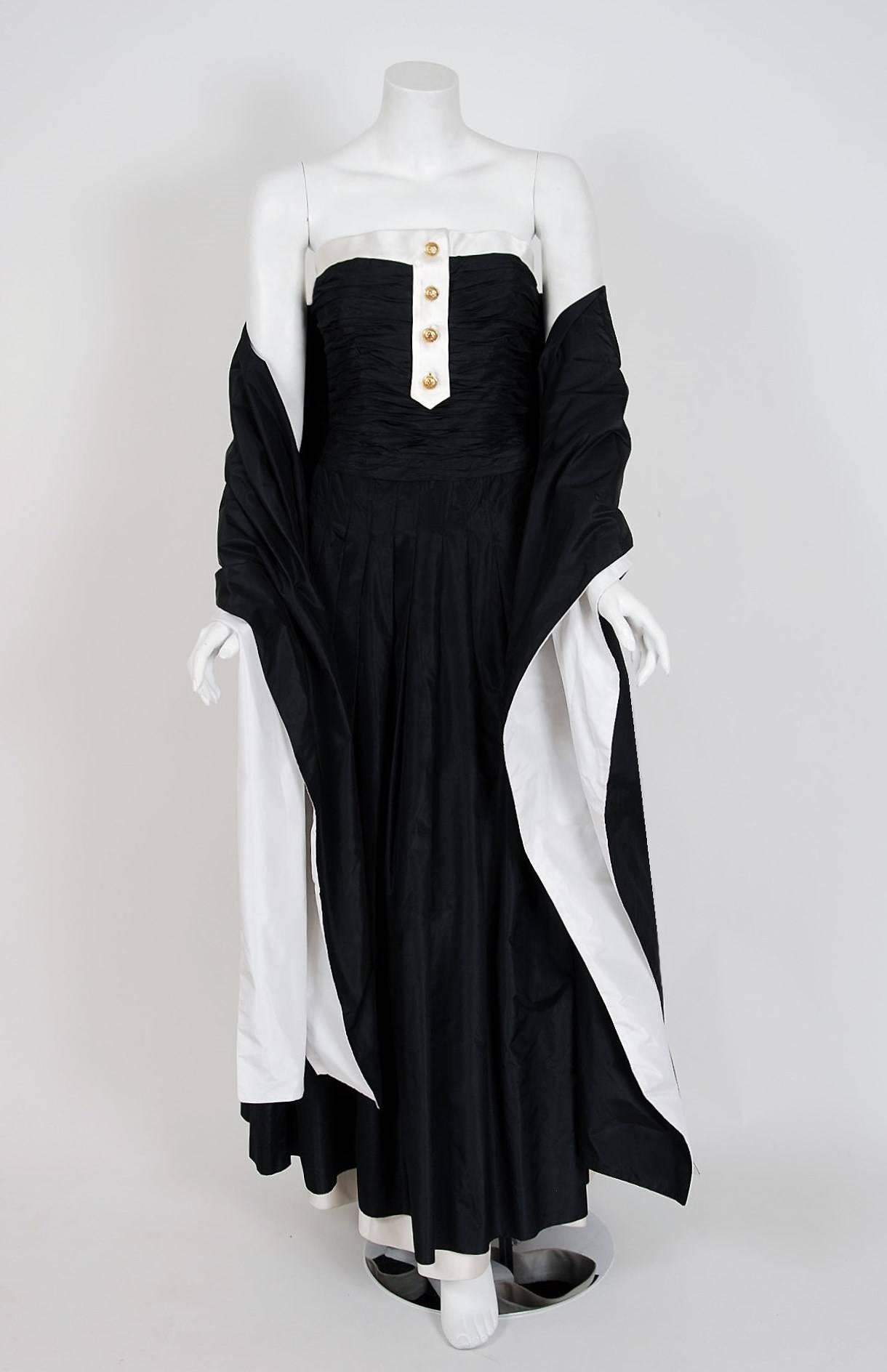 Chanel ist bekannt als eines der luxuriösesten und dekadentesten Modehäuser der Welt. Dieses atemberaubende schwarze Seiden-Taft-Kleid wurde erstmals auf dem Laufsteg der Pariser Modewoche 1992 präsentiert und ist ein perfektes Beispiel dafür::