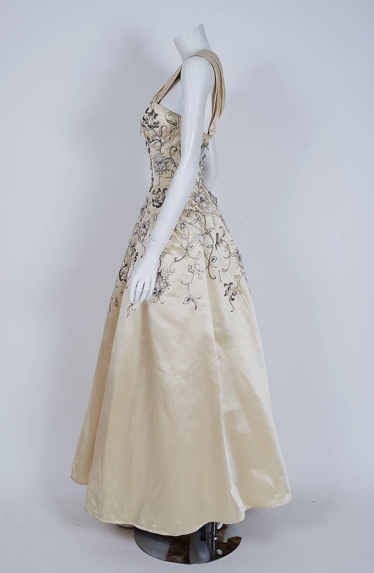 Breathtaking mid-1950's creme silk satin ballgown attributed to Pierre Balmain. This iconic designer created a very sculptural quality which was always allied with a ladylike essence. His garments have a body and a shape of their own. This