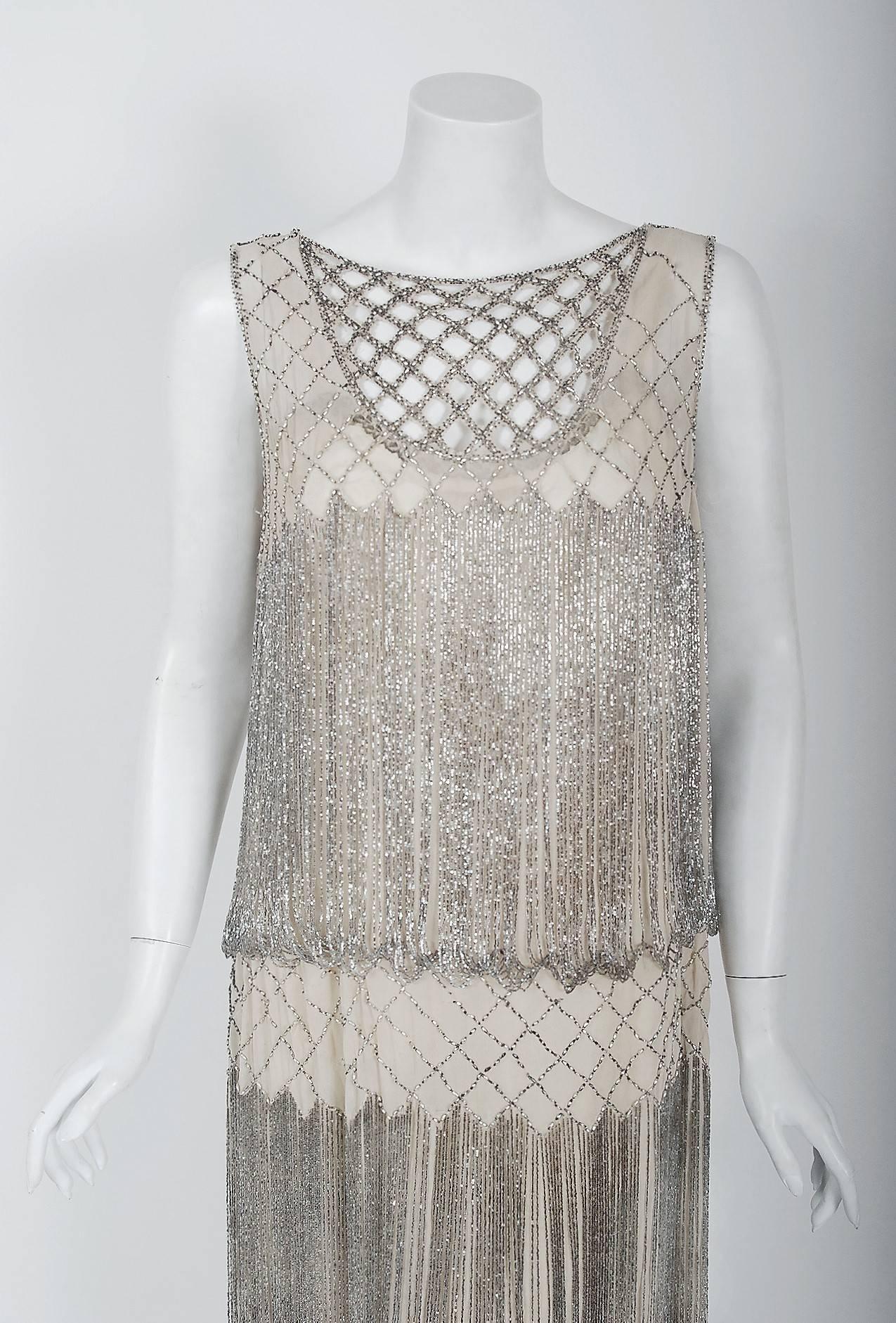Romantic flapper dresses from the early 20th century are perennial favorites and this one is a show-stopper! The garment's simple unstructured style is so modern; the fine beadwork is a treasure trove of needle art. This beauty, fashioned from