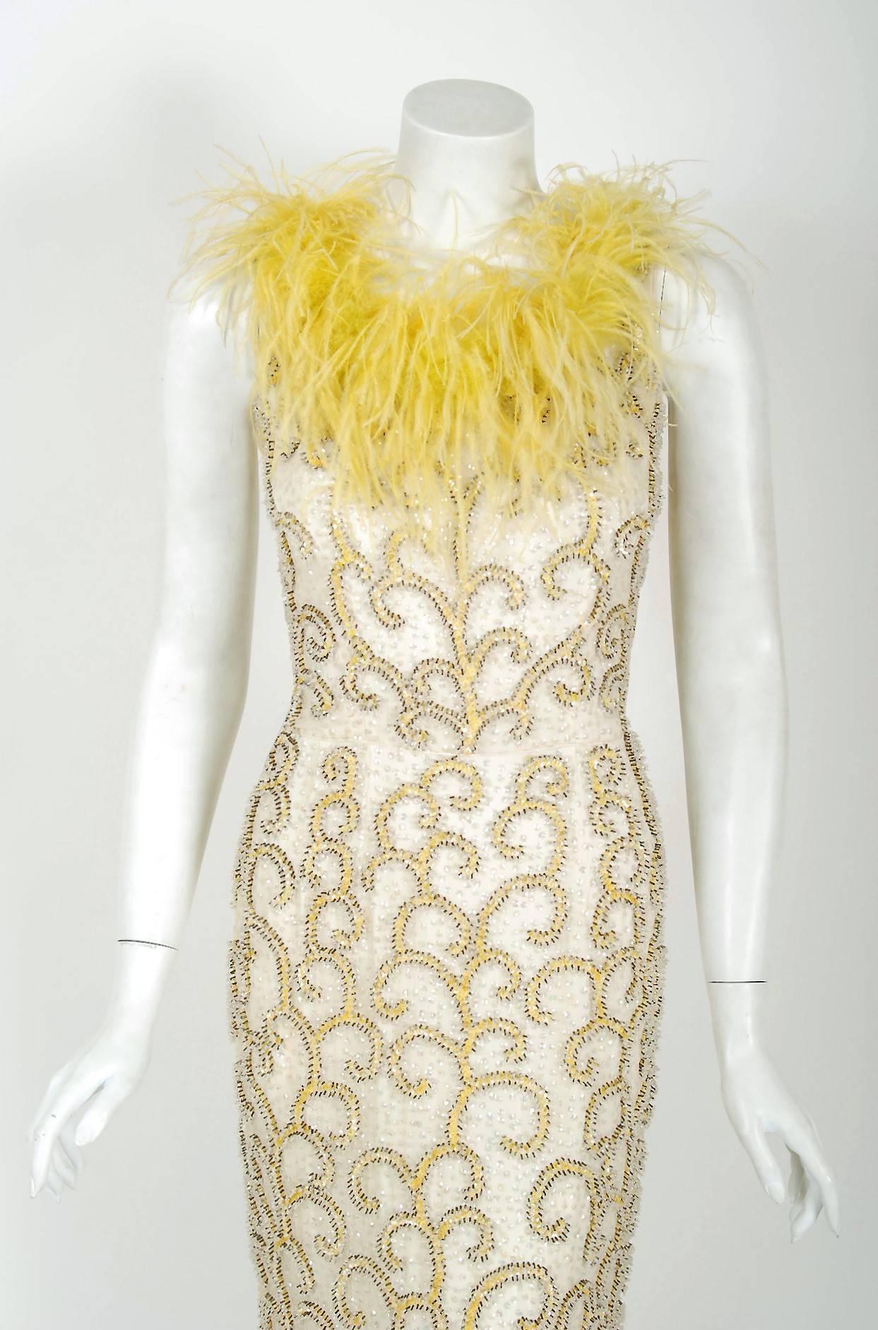 A breathtaking early 1960's fully-beaded hourglass gown that is simply in a class of its own! This treasure has a fantastic abstract swirl pattern worked in, featuring three-dimensional scrolls around dazzling glass-beads. The base is a soft