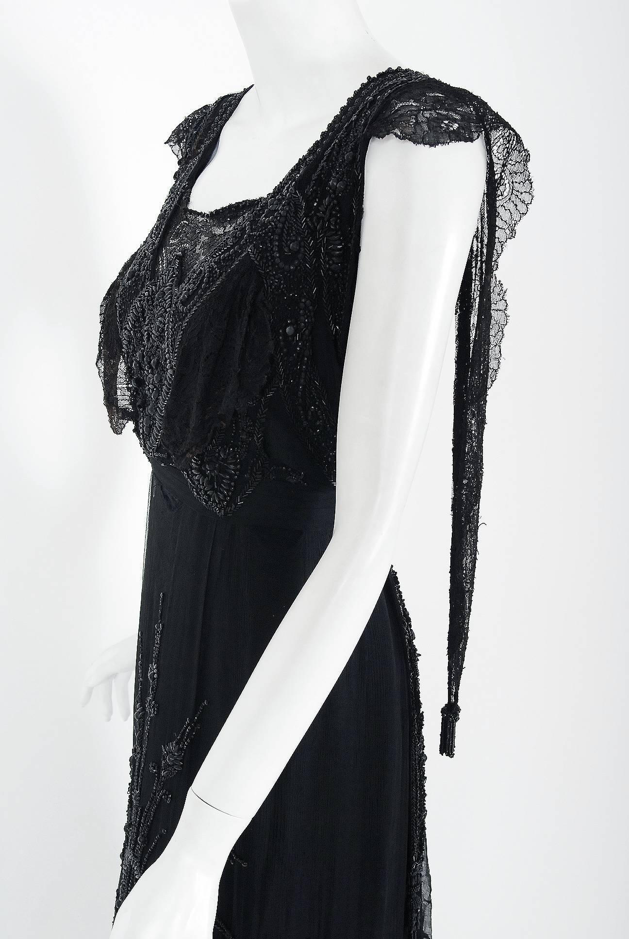 Undiminished by time, this antique evening gown still casts its seductive spell. An exceptional Edwardian tea-dress made of French chantilly-lace and silk lwith sheer black mesh net overlay, faceted beading and tassel applique. The breathtaking