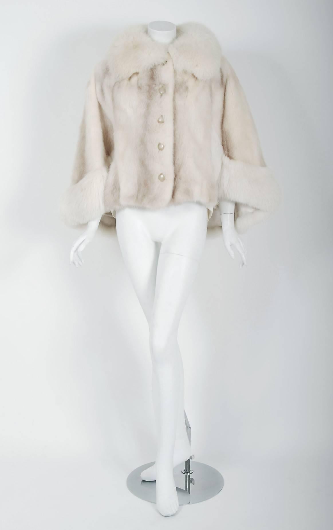 An extraordinary, ivory-white genuine mink and arctic fox cape that will make any woman shine during the winter season! It is easy to see the level of quality in this Diane Furs piece; the fur is extremely supple and soft. The jacket is pieced