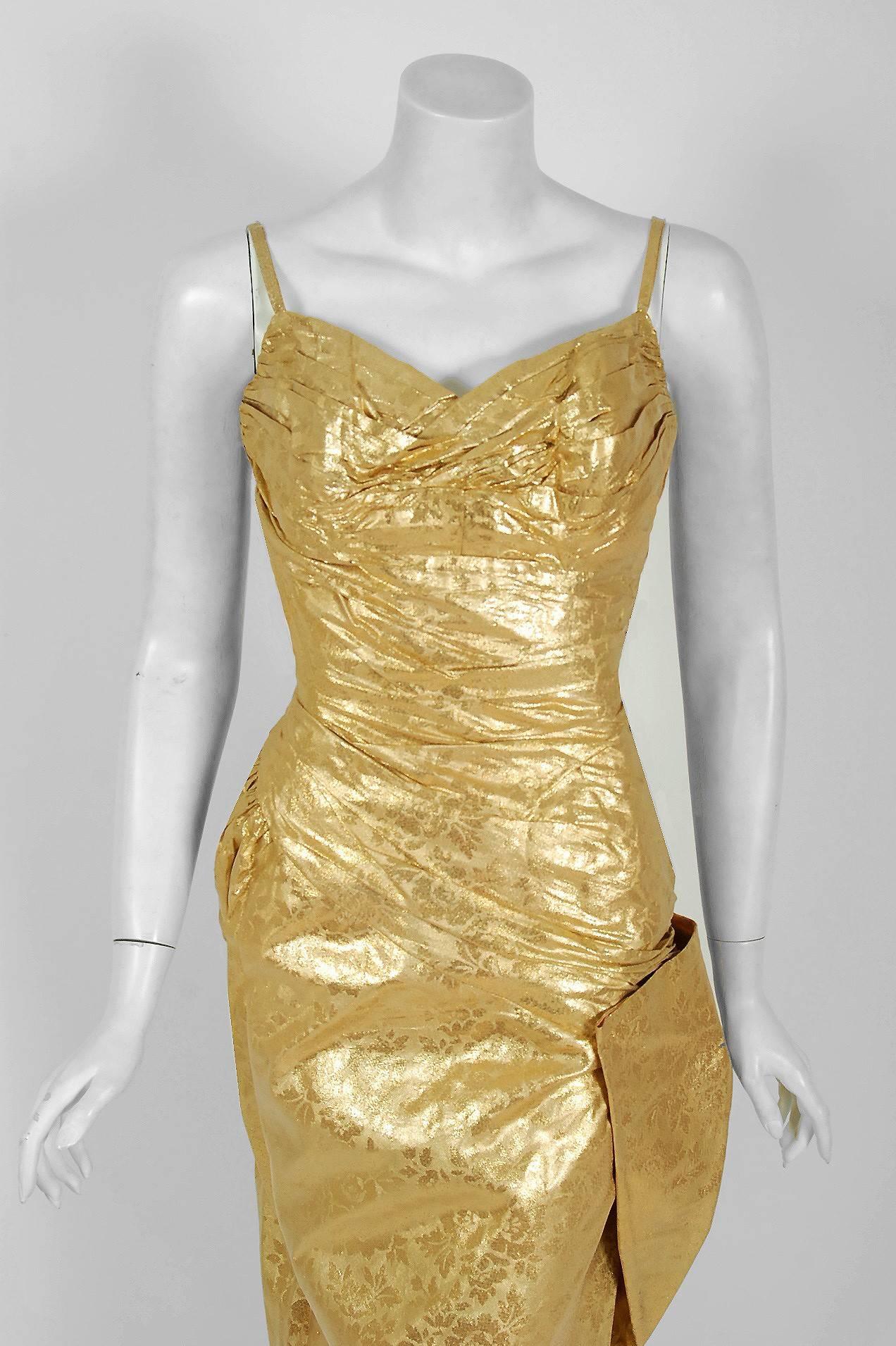 Stunning 1950's "Beaumelle" designer metallic-gold bombshell cocktail dress from the Old Hollywood era of glamour! The fabric itself is a masterpiece; shimmering floral-print metallic gold lined silk lamé. The bodice is an alluring low-cut