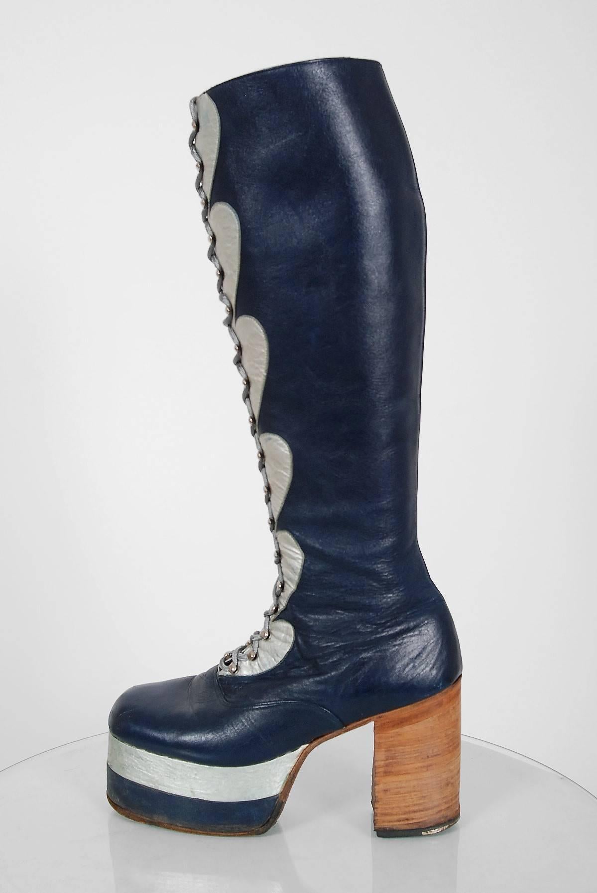 Amazing 1970's British custom-made leather boots in the most incredible cobalt blue and silver color combination. These boots have stacked wood heels with a two-tone leather covered high platform. I love the detailed novelty heart applique work and