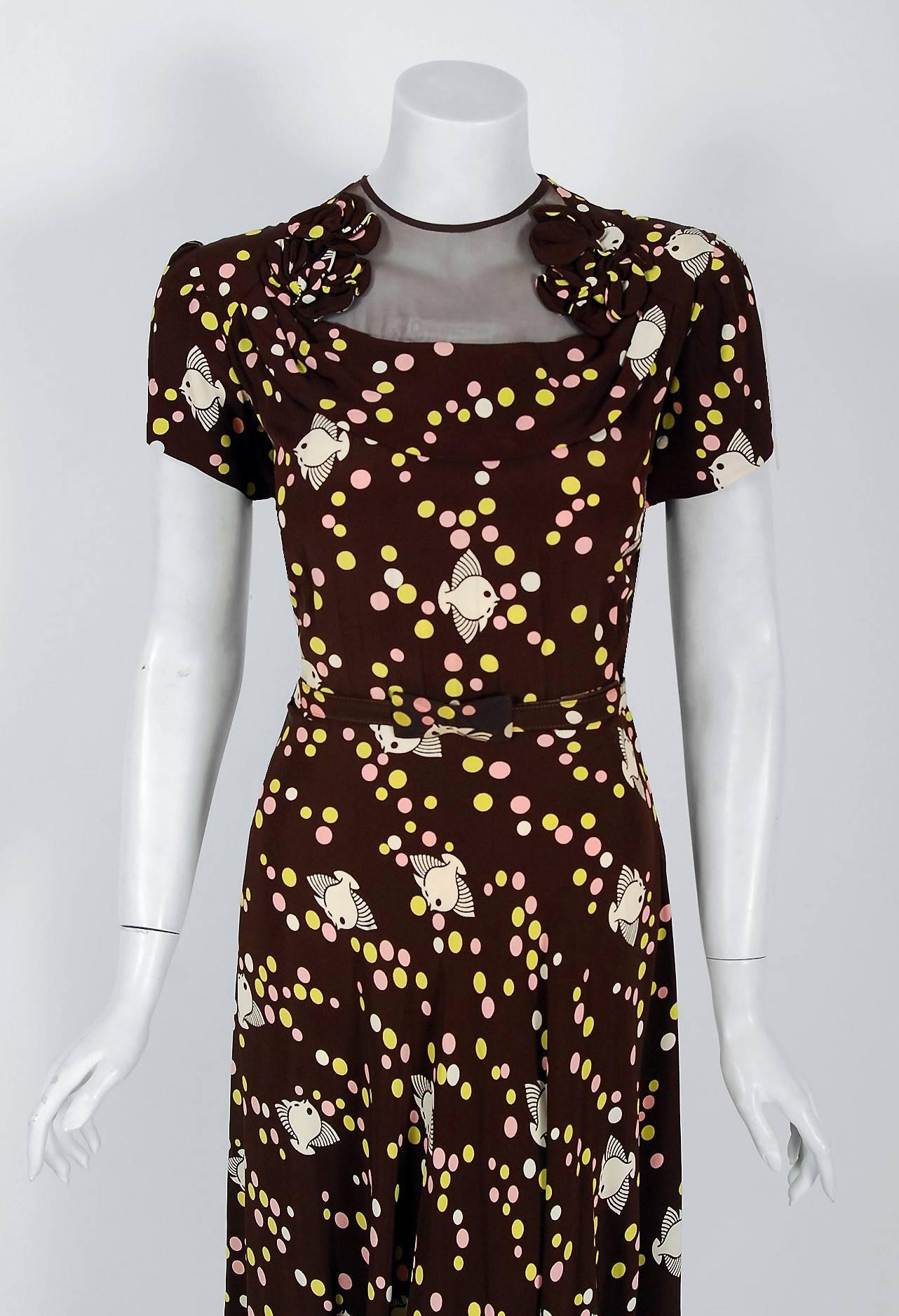 With its adorable swimming fish deco bubbles novelty print and flawless styling, this Semone Original dress has the casual elegance the 1940's were known for. The short-sleeve sheer illusion appliqued bodice is very flattering and effortless to