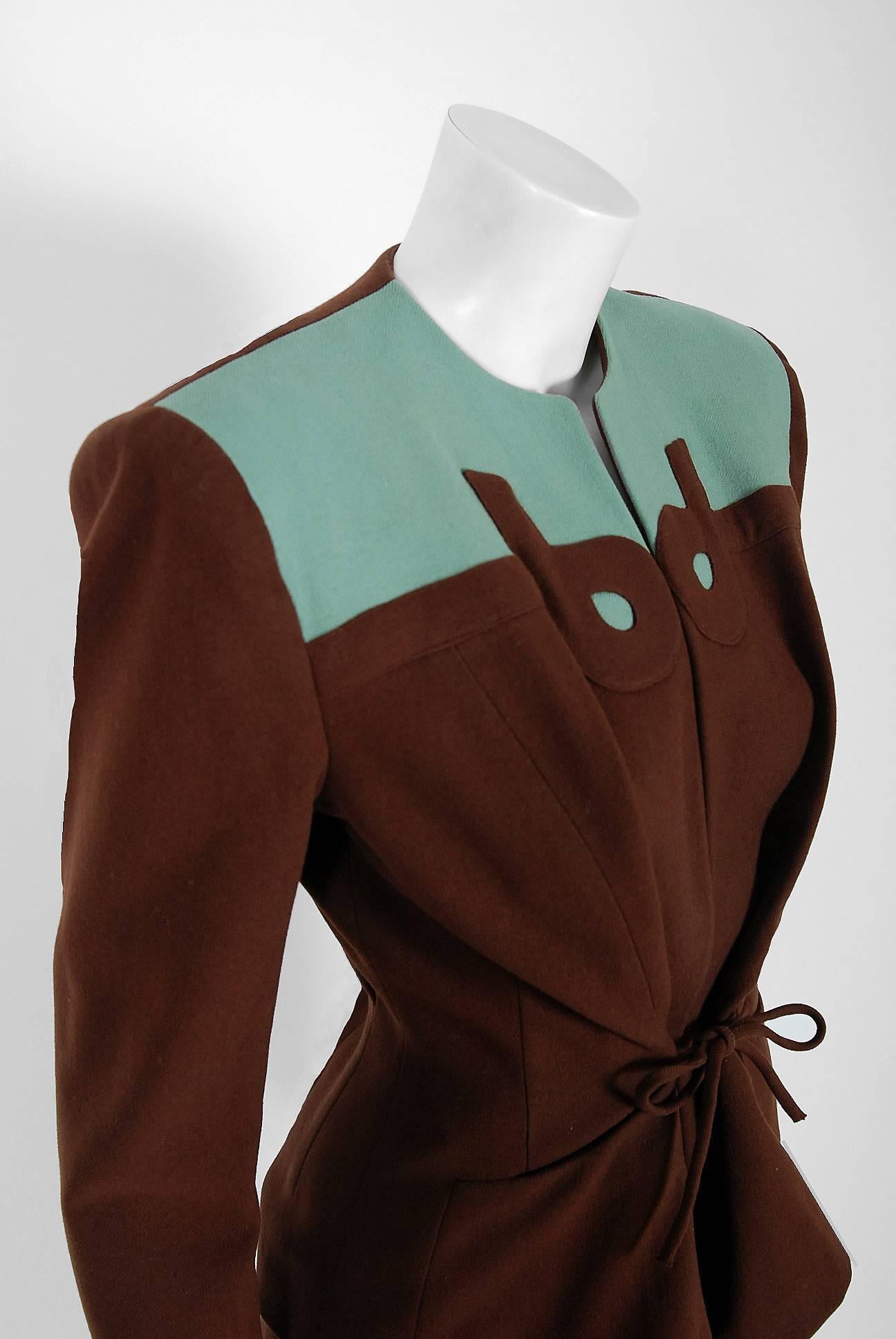 This stunning 1940's Audrey Alan Original two-piece ensemble is fashioned in turquoise blue and chocolate brown lined virgin-wool. The fabric itself is a masterpiece; vertical woven wool that seems to have an almost 3-dimensional feel without being
