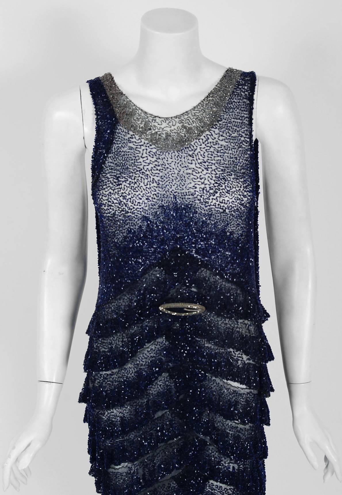 Undiminished by time, this 1920's French sapphire-blue and black flapper dance dress still casts its seductive spell. This exceptional Art Deco beauty is fashioned from sheer illusion cotton-net with sparkling glass beadwork throughout. The