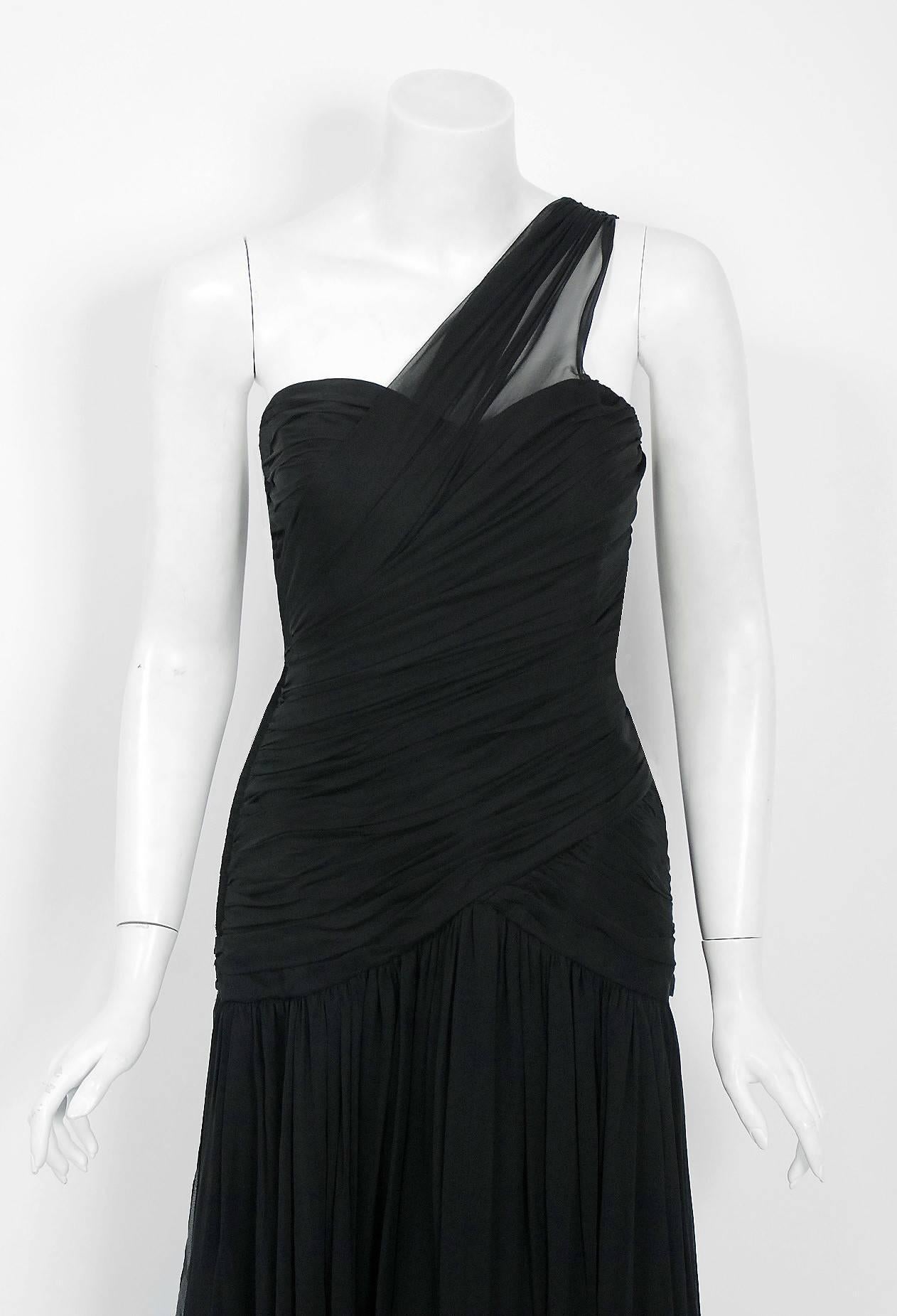 This breathtaking Adele Simpson designer gown, dating back to mid 1970's, is perhaps the most unique and flattering black dress I have ever seen. Fashioned from light-weight silk chiffon, the fabric feels like heaven against the  skin. The bodice is