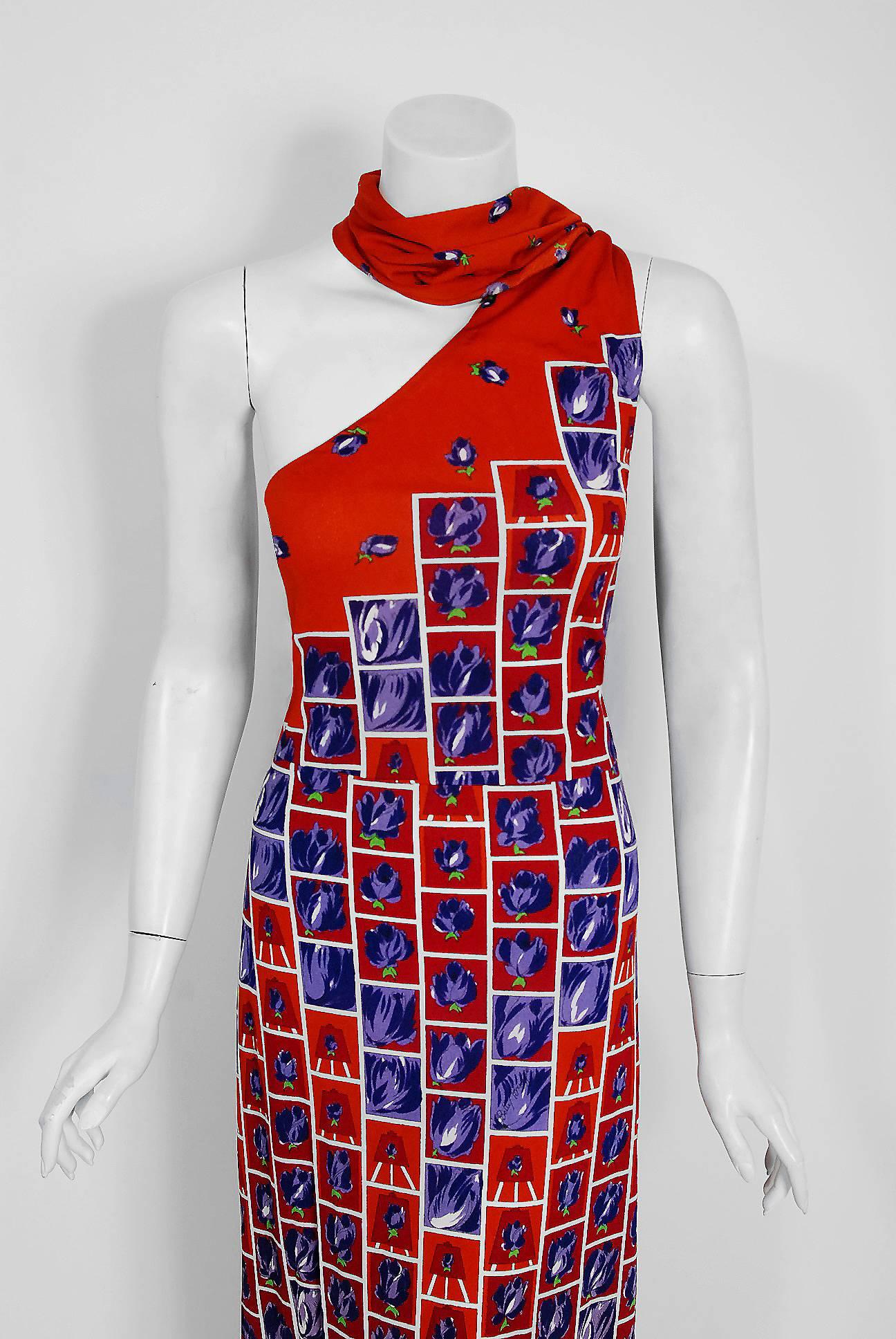 With its vibrant purple-roses graphic print and flawless styling, this Italian jersey dress has the bohemian elegance the 1970's were known for. The asymmetric one-shoulder scarf bodice is very flattering and effortless to wear. The nipped waistline