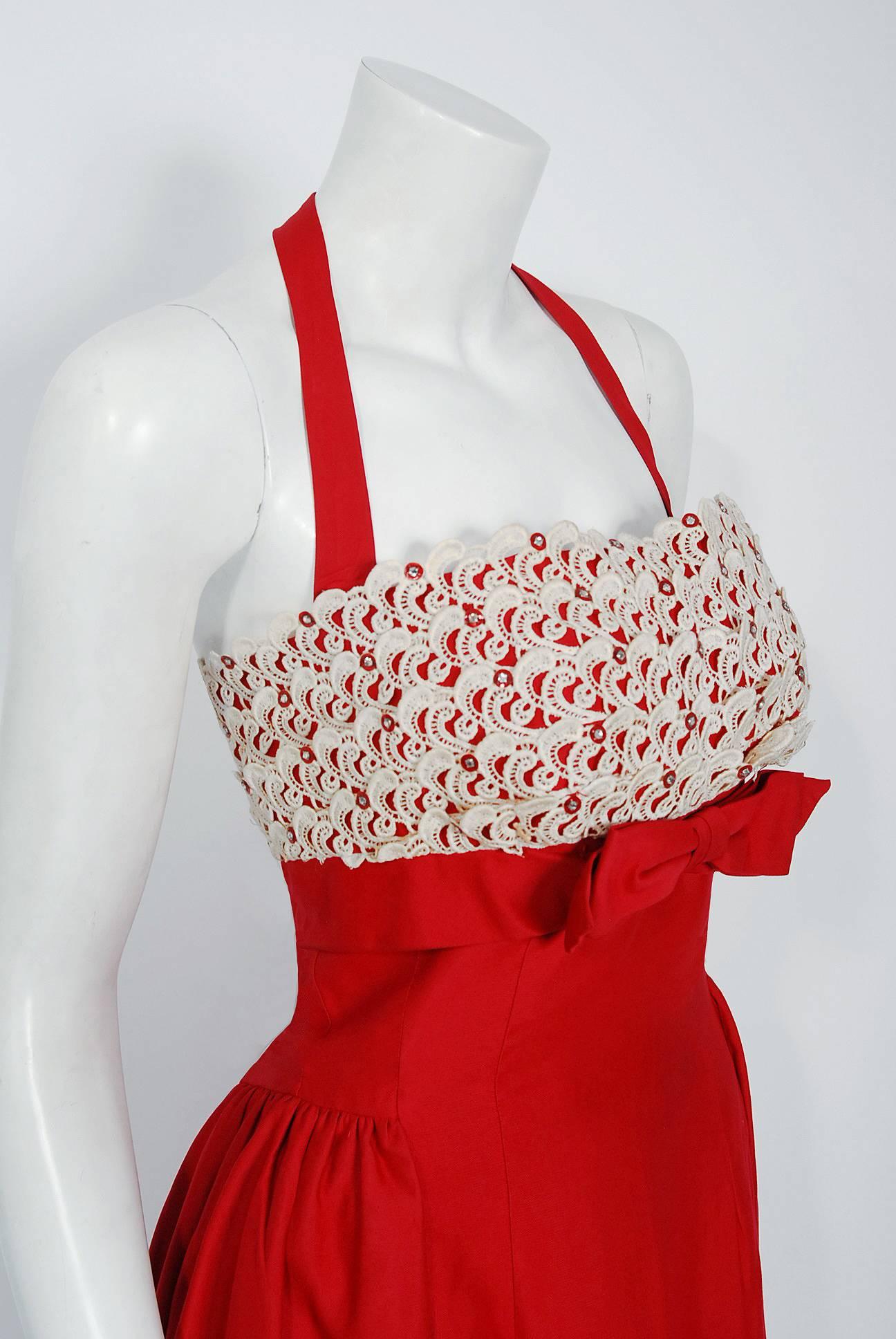 An amazing and highly stylized 1950's cocktail sundress by the Lou-Ette California designer label. This gorgeous garment is fashioned from a ruby-red polished cotton silk blend with ivory lace applique. The silhouette is classic pin-up "femme