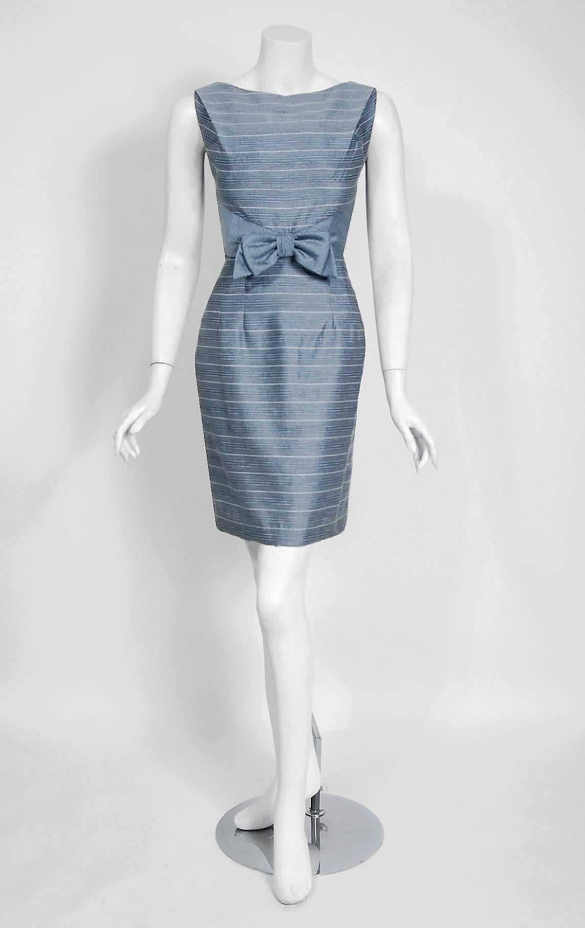 An amazing and highly stylized baby-blue stripe woven silk cocktail dress ensemble dating back to the early 1960's. The silhouette is classic pin-up "femme fatale"; the skirt is deliciously lean! The bodice is an ultra chic boat-neck