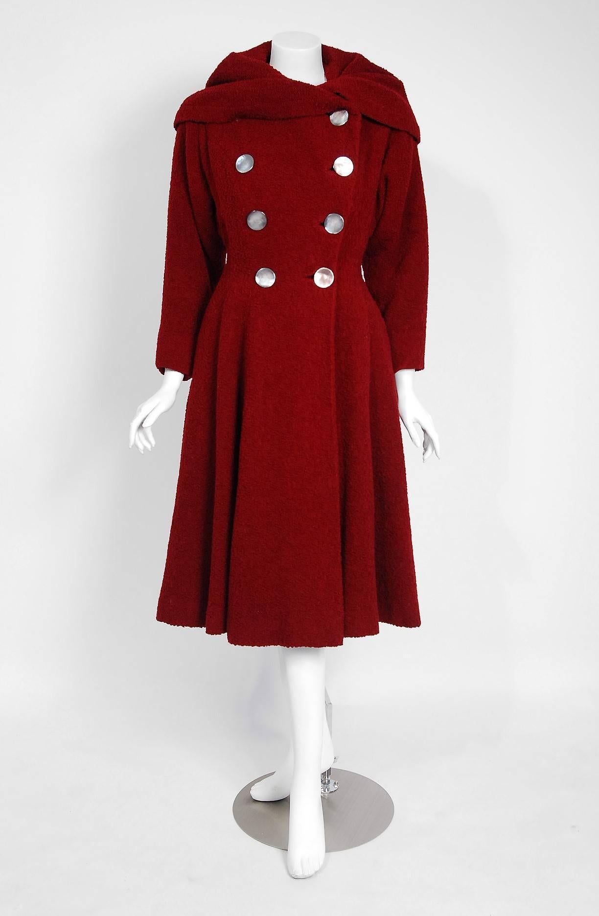 Stunning 1940's couture level coat in the most fabulous burgundy red chenille wool. I love the dramatic velvet-backed wide shawl collar and double breasted design. I adore those large pearlized buttons. Shaped with princess-line seams that flare out
