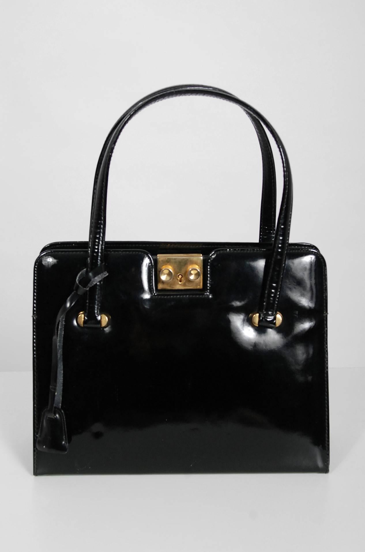 Stunning and sophisticated black patent leather purse by Guccio Gucci. This 1960's handbag is fashioned from the highest grade leather and accented with gold-metal throughout. I love the original lock/key closure design and inside duel-pockets. In