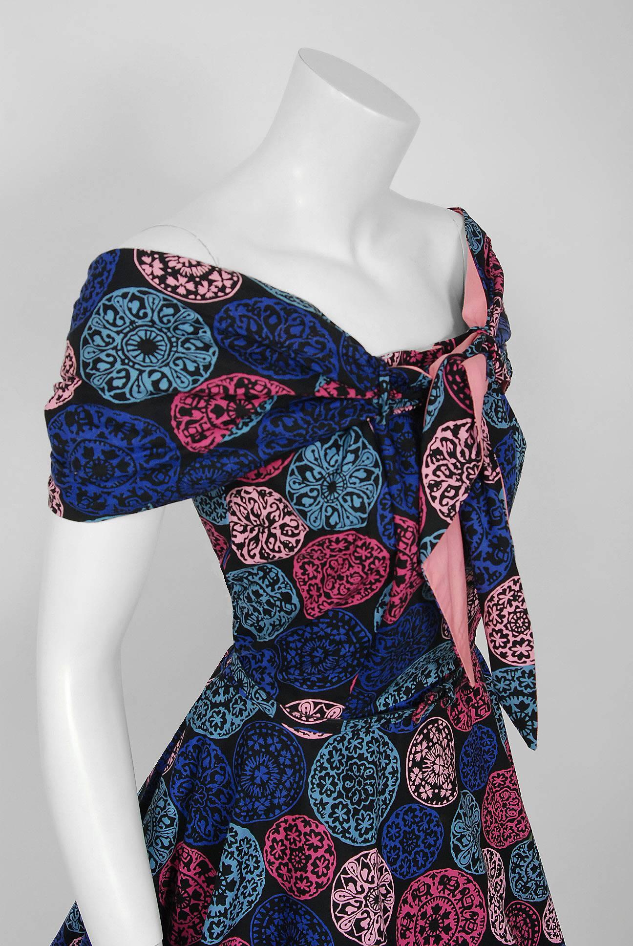With its vibrant novelty print and flawless 'new look' silhouette, this Toni Hunt designer sundress ensemble has the casual elegance the 1950's were known for. The pattern alone is sensational; large scale dotted medallions in hues of blue, pink