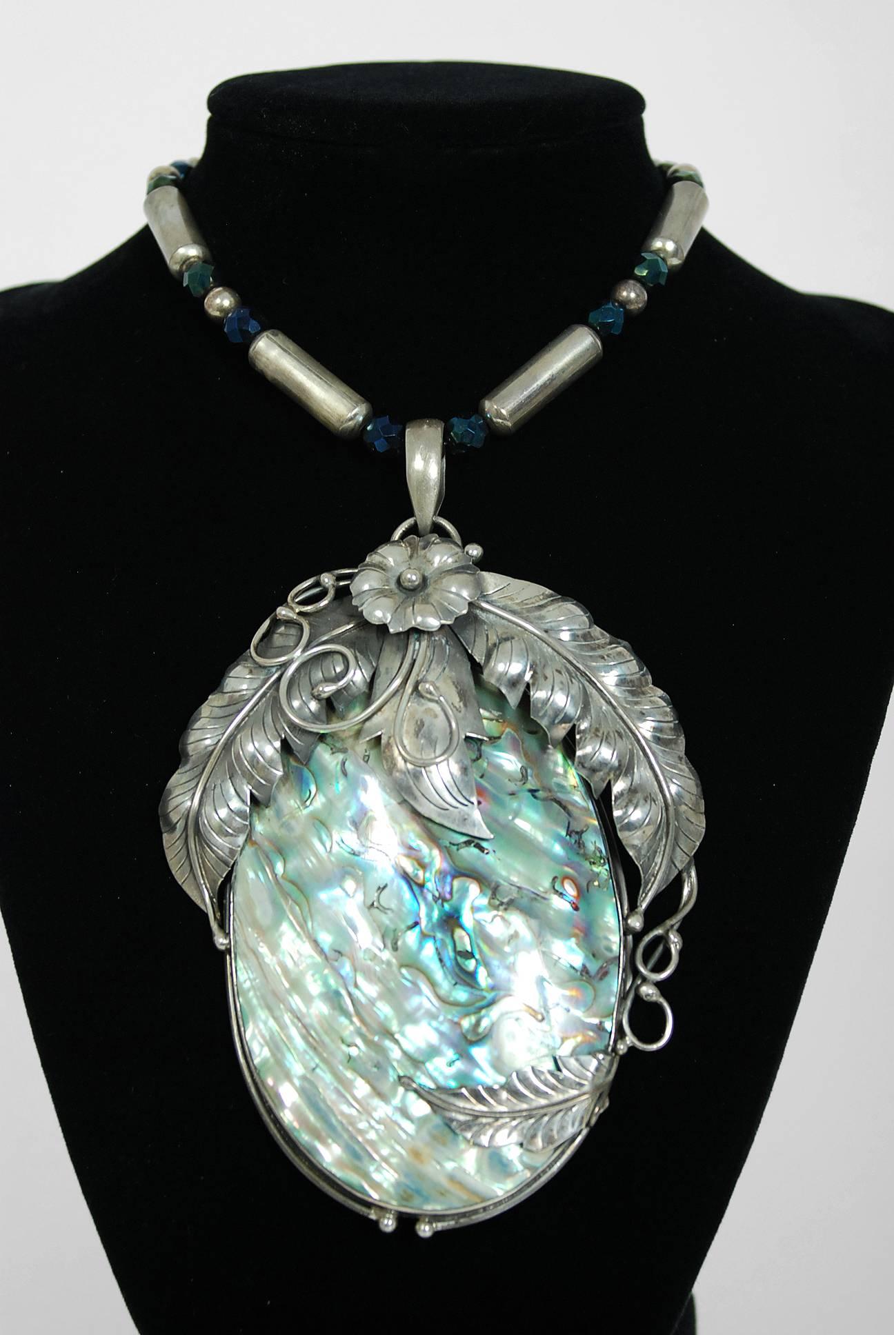 Gorgeous Native American rainbow abalone and genuine sterling silver huge statement necklace dating back to the mid 1970's. The piece has been crafted in a stunning feather motif with texture to showcase the over-sized pendant. The abalone 'sea