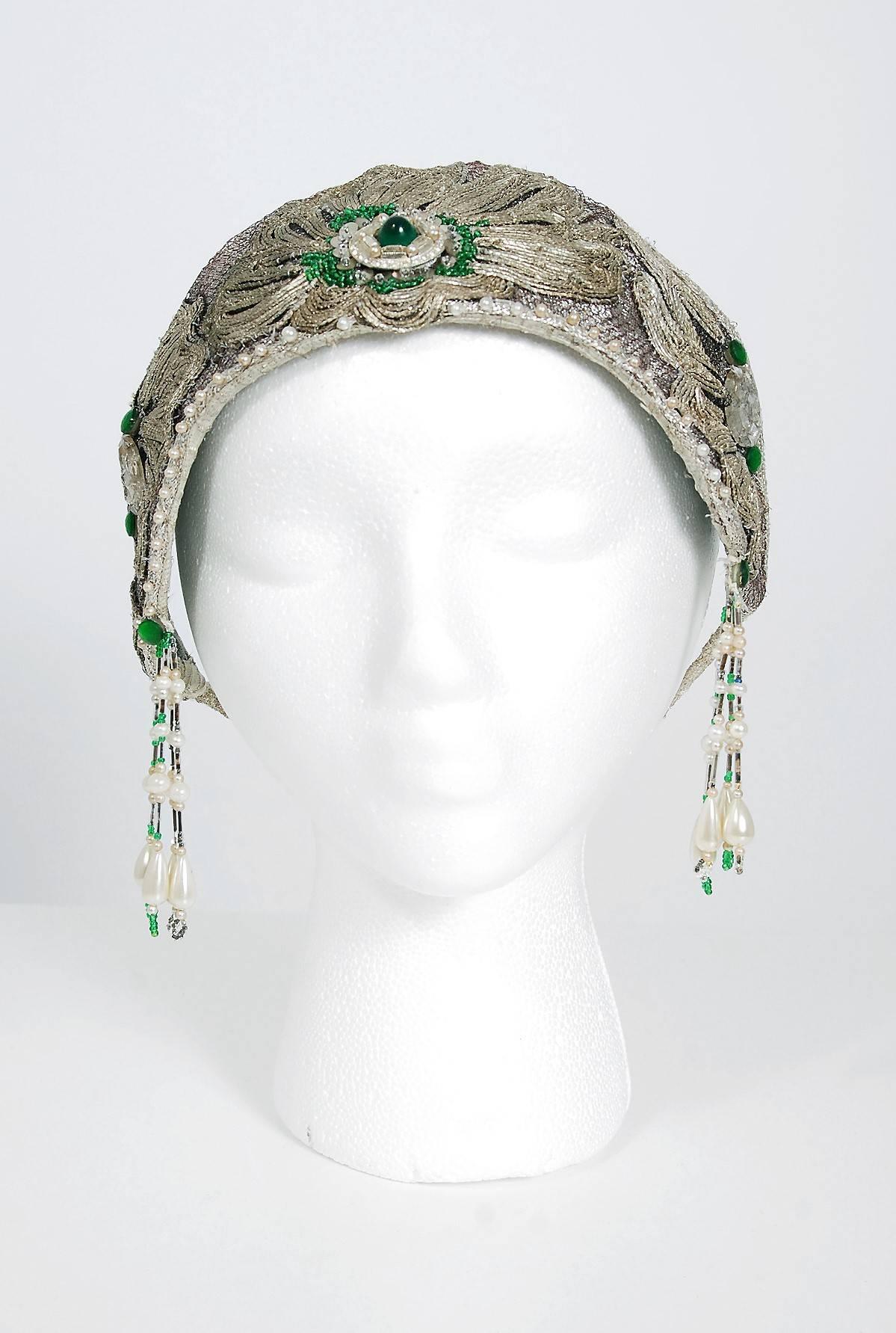Breathtaking 1920's French metallic silver lamé and emerald-green jeweled flapper headpiece. This is, without a doubt, one of the most extraordinary antique crowns I have ever laid eyes on. Large scale jewels, sequins and glass-beads with tons of