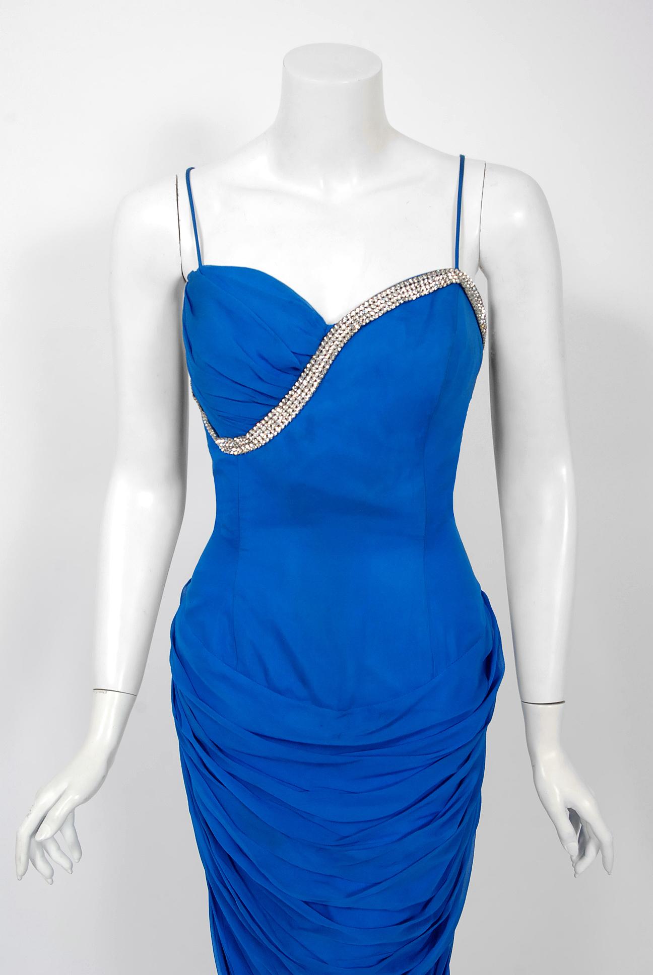 A seductive and highly stylized 1950's sapphire-blue silk chiffon cocktail by the famous Lilli Diamond. The silhouette is classic pin-up 