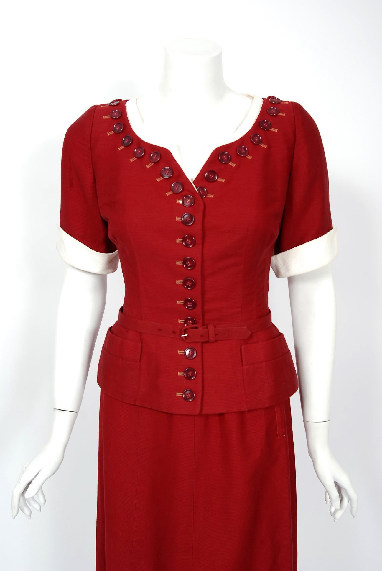 A gorgeous 1940's uniquely-taliored burgundy three piece ensemble by the American designer, Paul Parnes. The fabric itself is a masterpiece; mid-weight textured cotton with chic white cotton pique trim. The short-sleeve blouse has a dramatic button