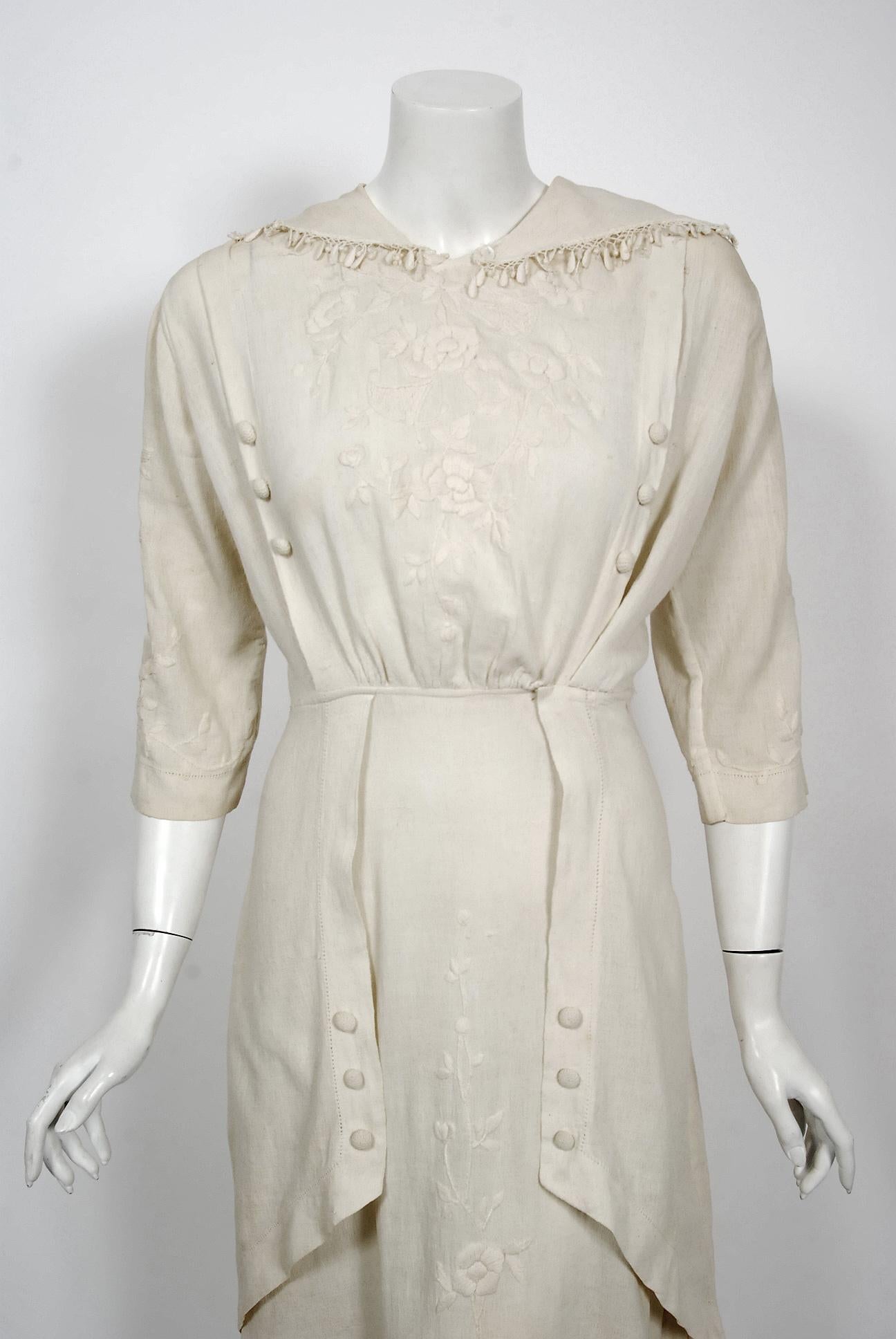 This ethereal Edwardian couture ivory silk-crepe tea gown, with an abundance of embroidery, is of the highest quality. The garment was discovered with provenance; tagged 'Bessie Andrews white crepe dress 1916'. The stylized charm of the embroidered