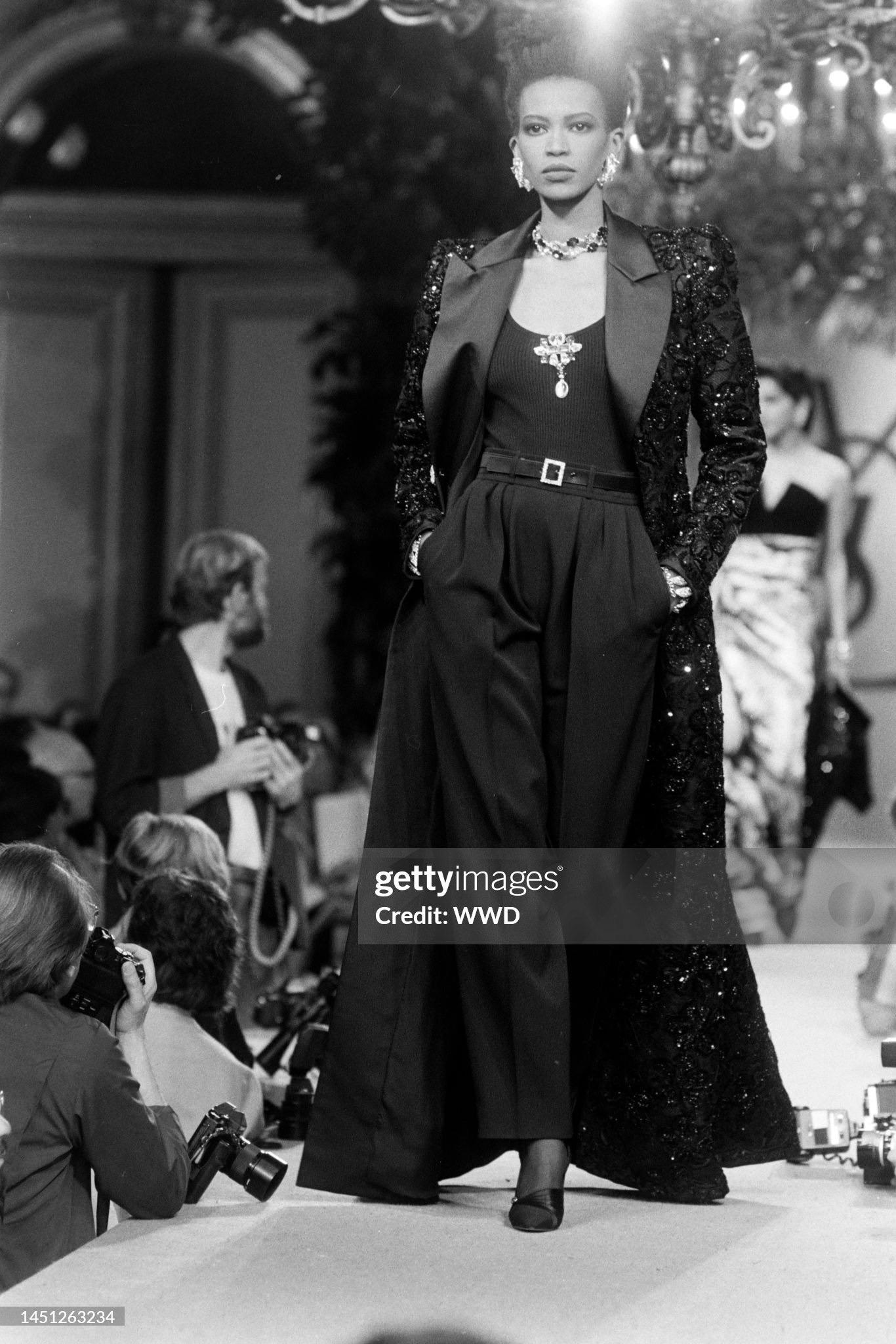 Breathtaking and totally iconic Yves Saint Laurent haute couture maxi length tuxedo jacket dating back to his beloved 1984 fall-winter collection. It is insanely chic with its fluid femme fatale sculpted construction yet masculine approach. The