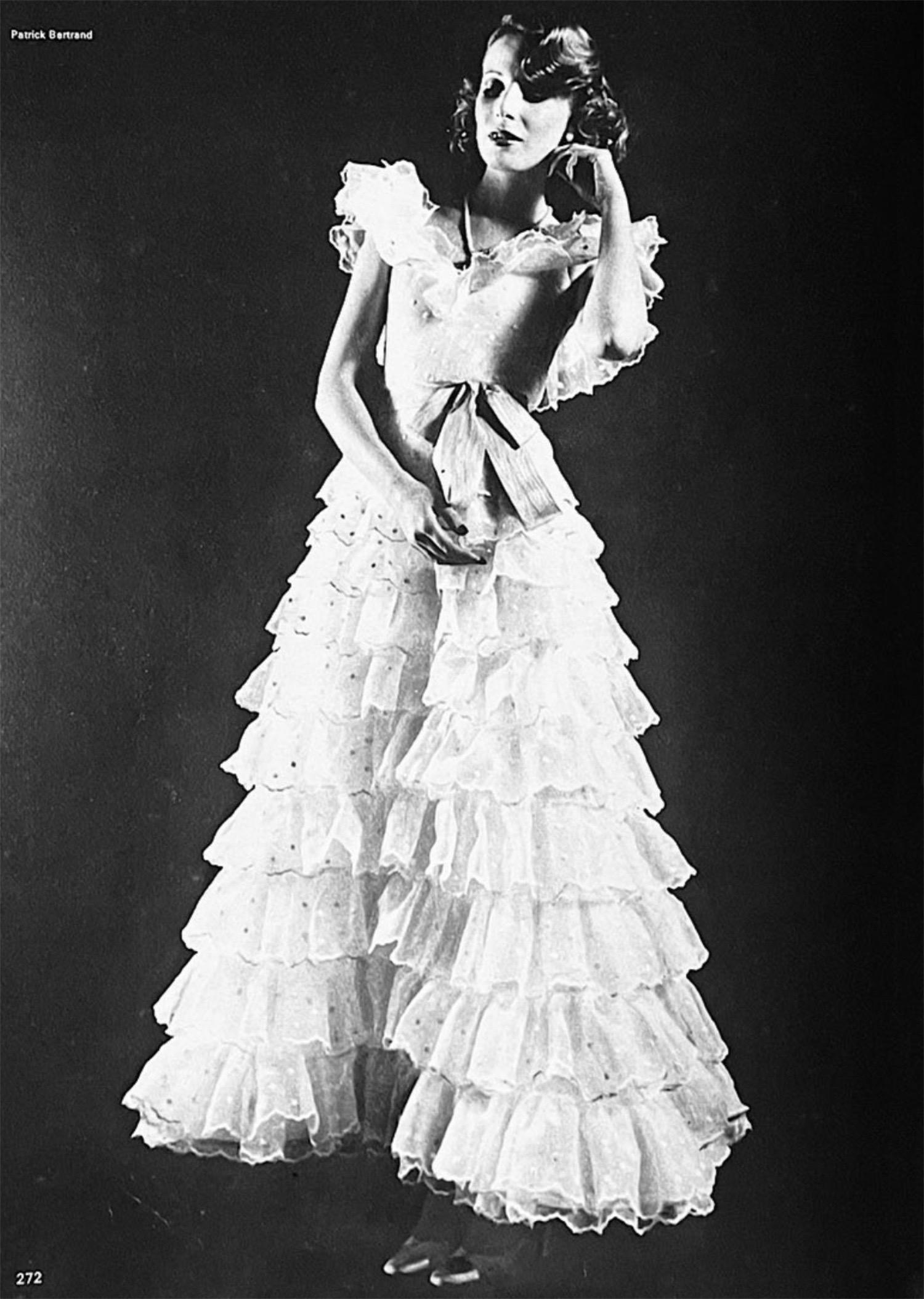 Chanel is known to be one of the most luxurious and decadent fashion houses in the world. This breathtaking, well-documented archival Chanel 1975 spring/summer ivory white polka-dot embroidered silk organza haute couture gown, look #49, is a perfect