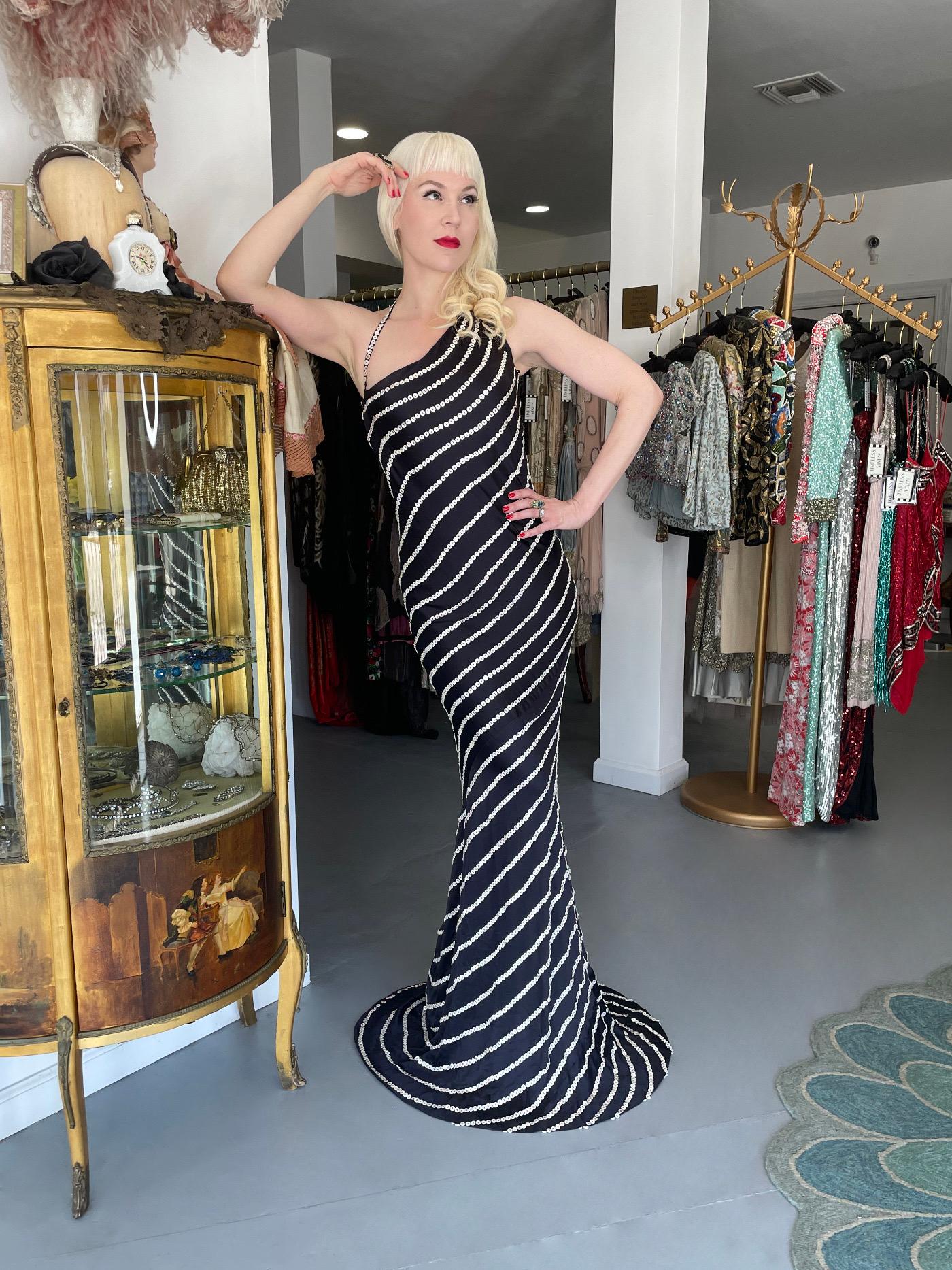 An ultra glamorous and highly coveted Alexander McQueen navy blue liquid silk satin button embellished stripes bias-cut gown dating back to his sensational 2003 spring-summer 'Irene' collection. Though not a runway look, this rare dress has the same