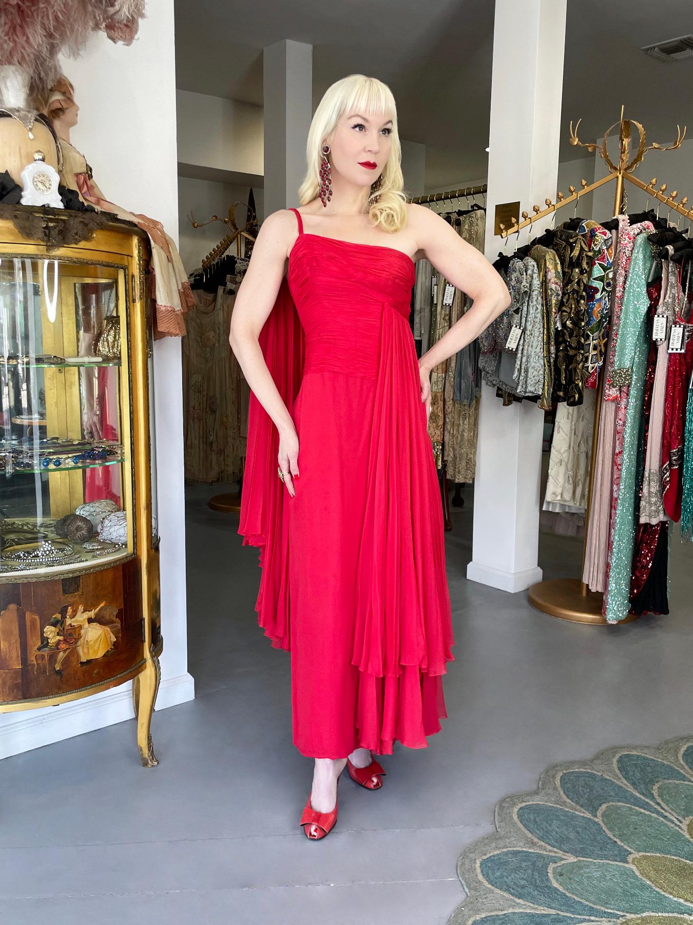 A rare and extraordinarily beautiful Martha Weathered pleated red silk chiffon one-shoulder grecian goddess gown dating back to the early 1960’s. This dramatic look exudes timeless elegance and impeccable craftsmanship. Martha Weathered’s shop,