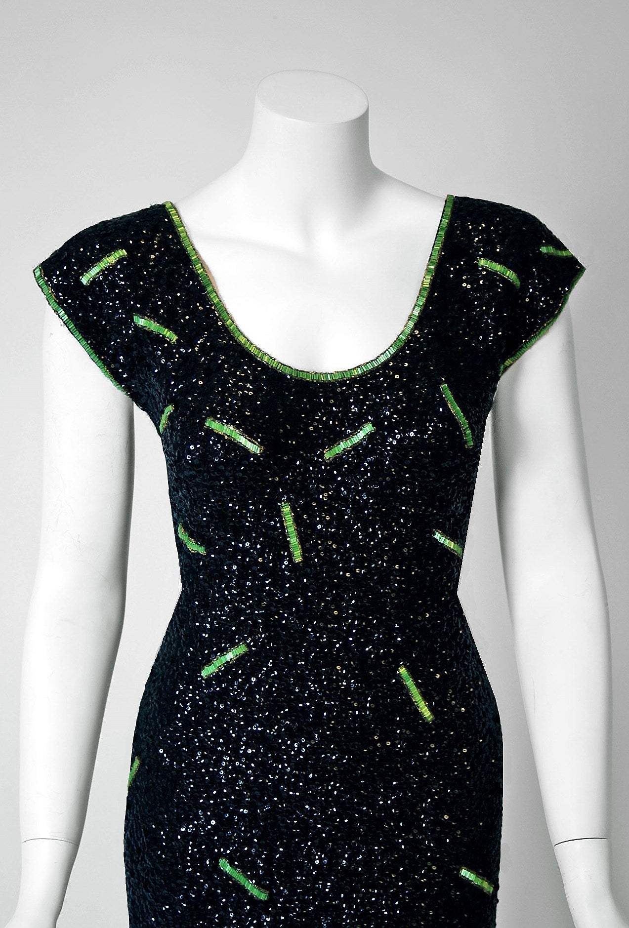 1950's Gene Shelly designer garments are in a class of their own. They are always fully-sequined by hand and fit to flatter the figure. This treasure has a fantastic abstract pattern, featuring clear glass-beads around green jewels. The base is a