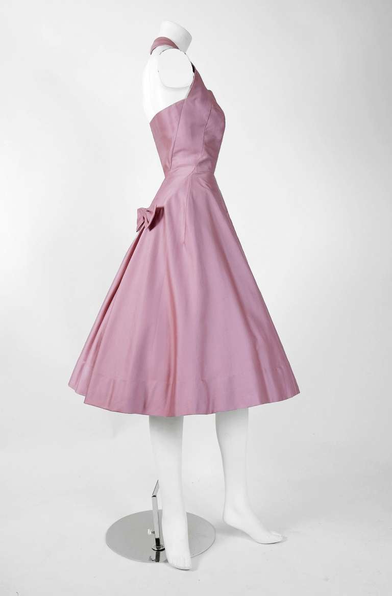 Jean Desses couture garments are rare, unique and highly collectible. This exquisite dress dates back to when Jean Desses housed his couture at the famous 17, Avenue Matignon address. Fashioned from exquisite mauve-pink cotton, this show-stopper has