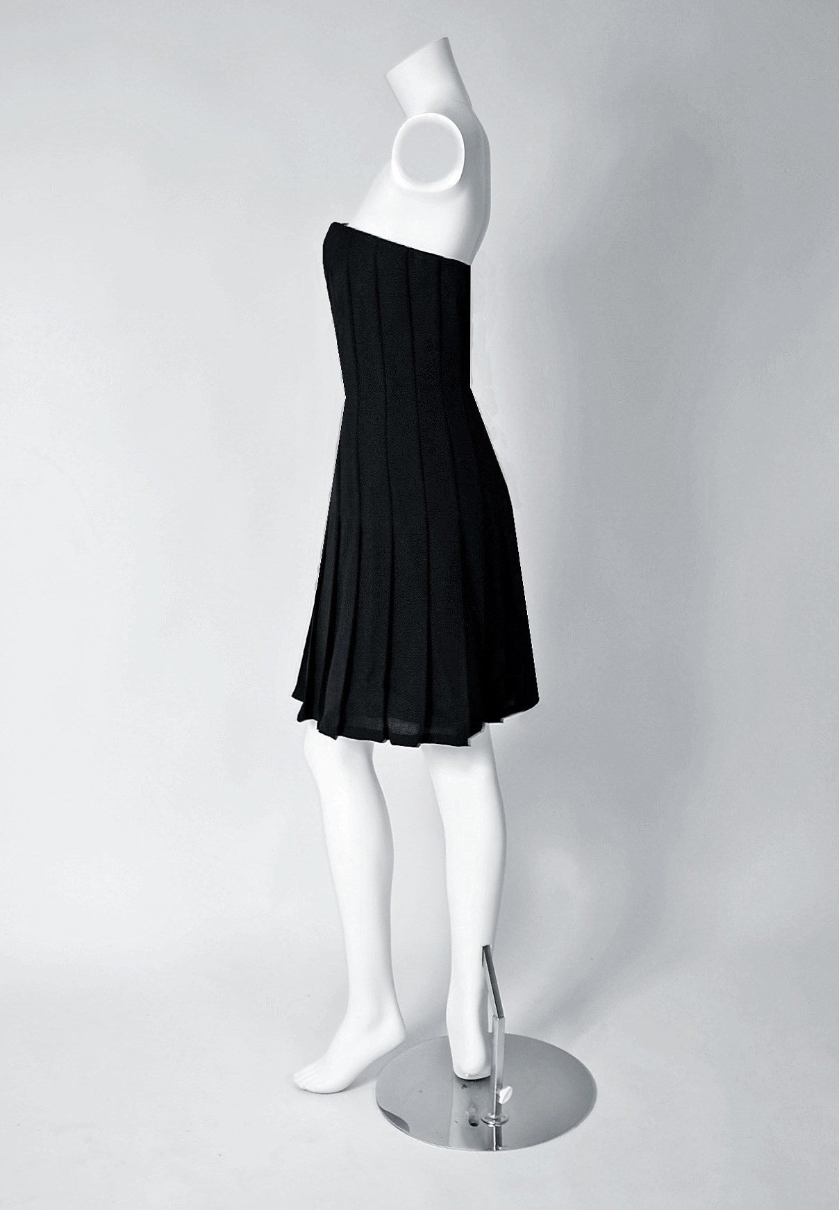 In 1975 Bill Blass brought back the cocktail dress, which had all but disappeared from the fashion scene. This captivating black rayon-crepe number, from the early 1990's, has everything a woman wants. The bodice is a low-cut plunge boned strapless.