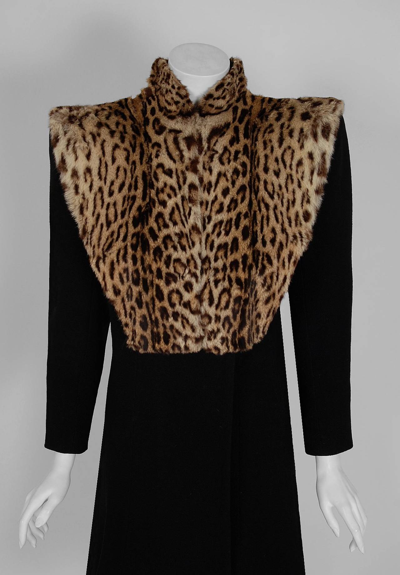 This exquisite early 1940's black wool-crepe and genuine geoffroy-cat fur coat will make any woman shine during the upcoming cold winter months! The breathtaking spotted fur has been worked into a unique high-collar bib and the effect is really