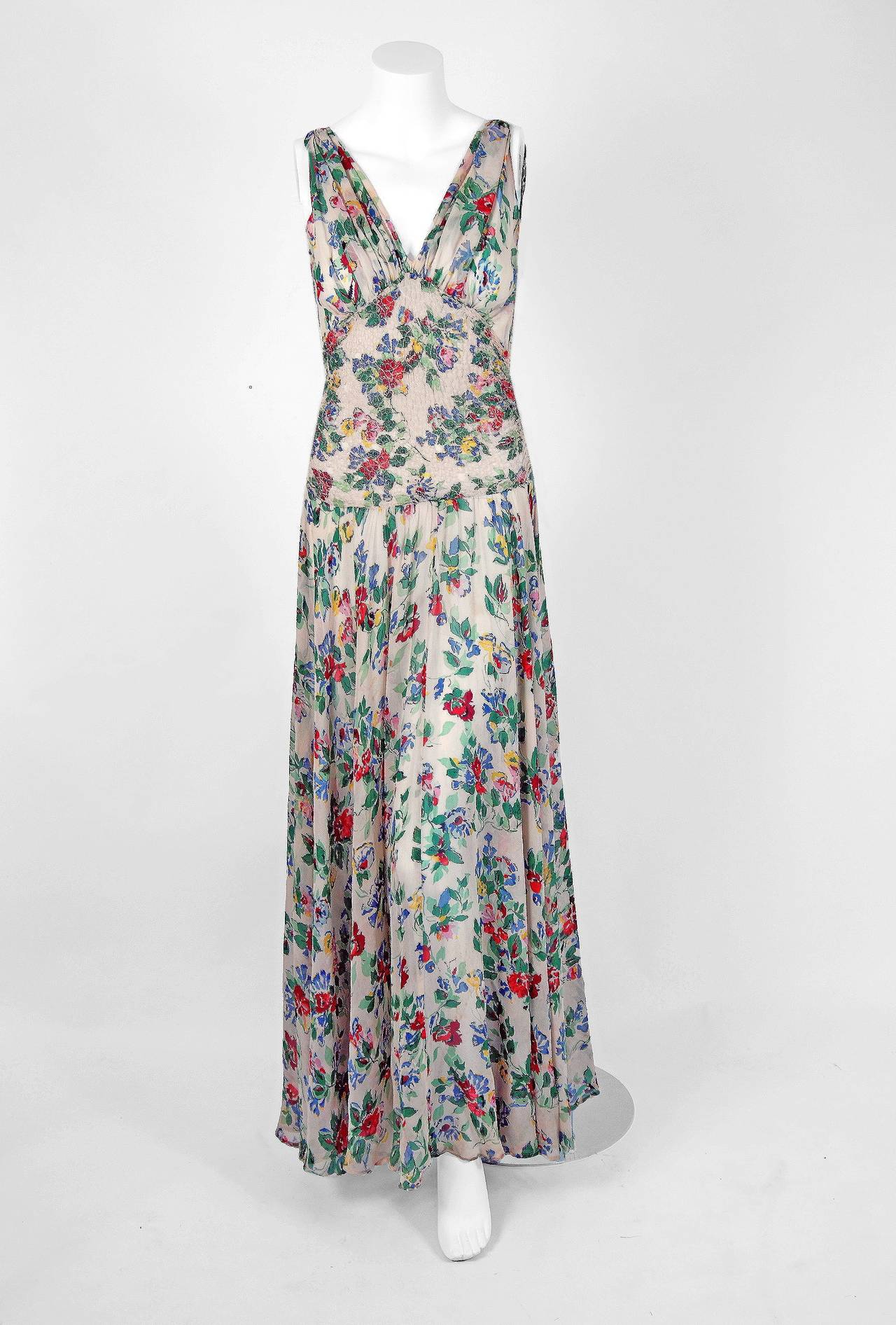 Alluring early labeled 1940's Ceil Chapman silk-chiffon gown in the most stunning colorful floral-garden print! I adore the low-cut plunge, sleeveless bias-cut bodice and it is incredible that the original bolero-jacket is still present. The smocked