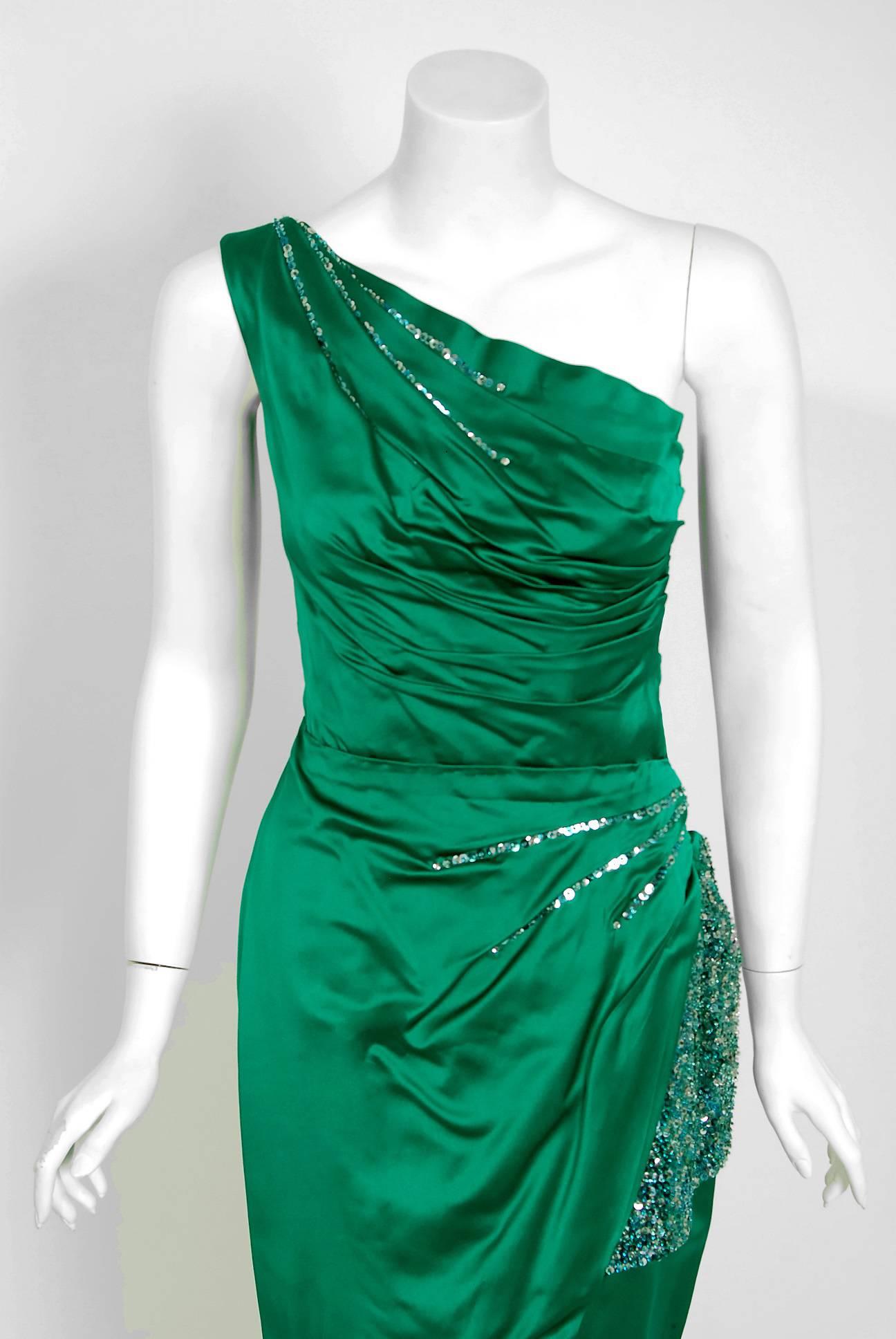 This is such a seductive and dramatic evening gown from the iconic Ceil Chapman designer label. Perfect for any upcoming event; you can't help but feel feminine in this beauty! The garment is fashioned from stunning mid-weight green silk satin.