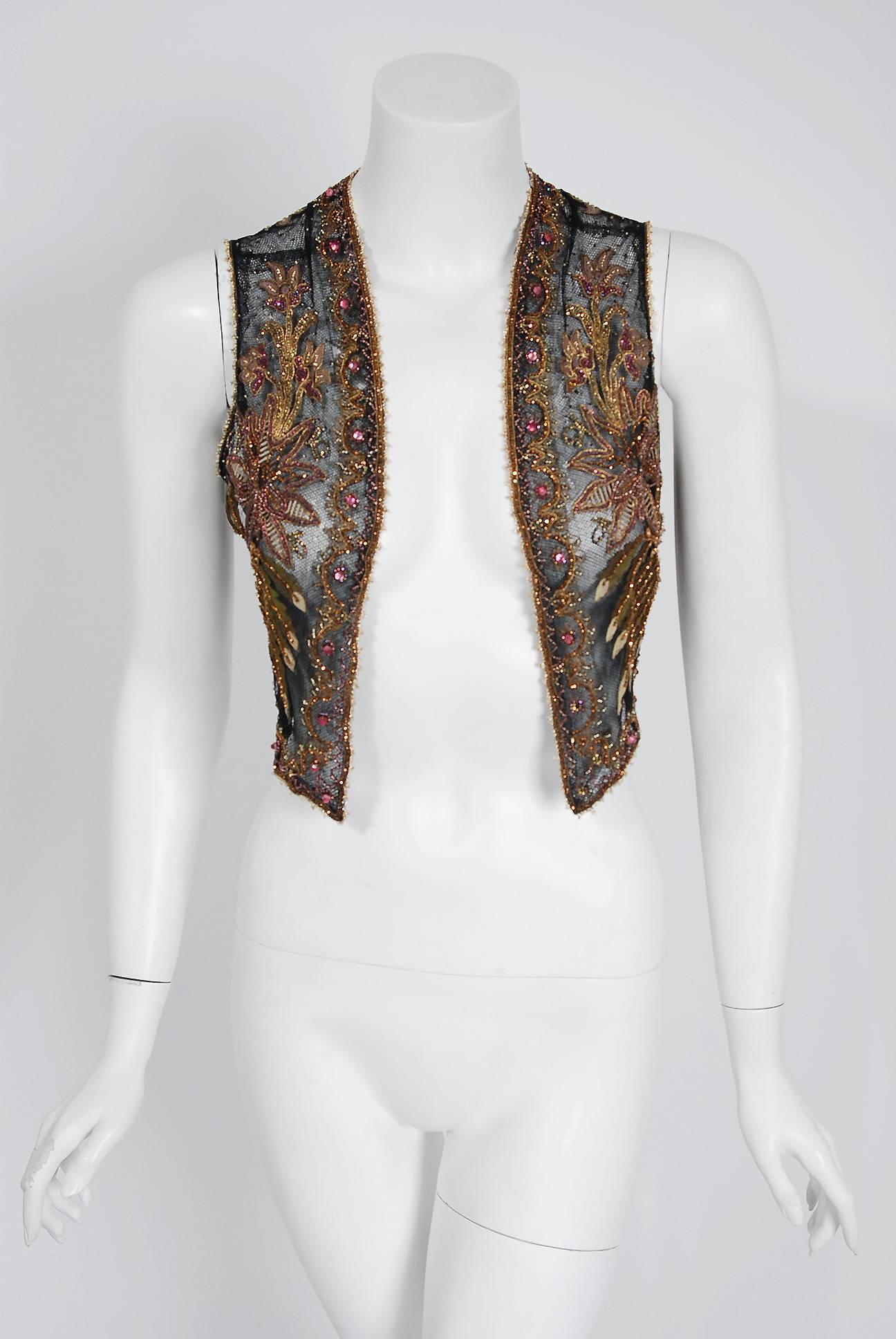 This sensational 1910's French Edwardian bolero vest is lavishly embellished with glossy glass beads and sparkling jewels throughout. The highly stylized floral embroidery perfectly captures the Art Nouveau aesthetic. Double layered 