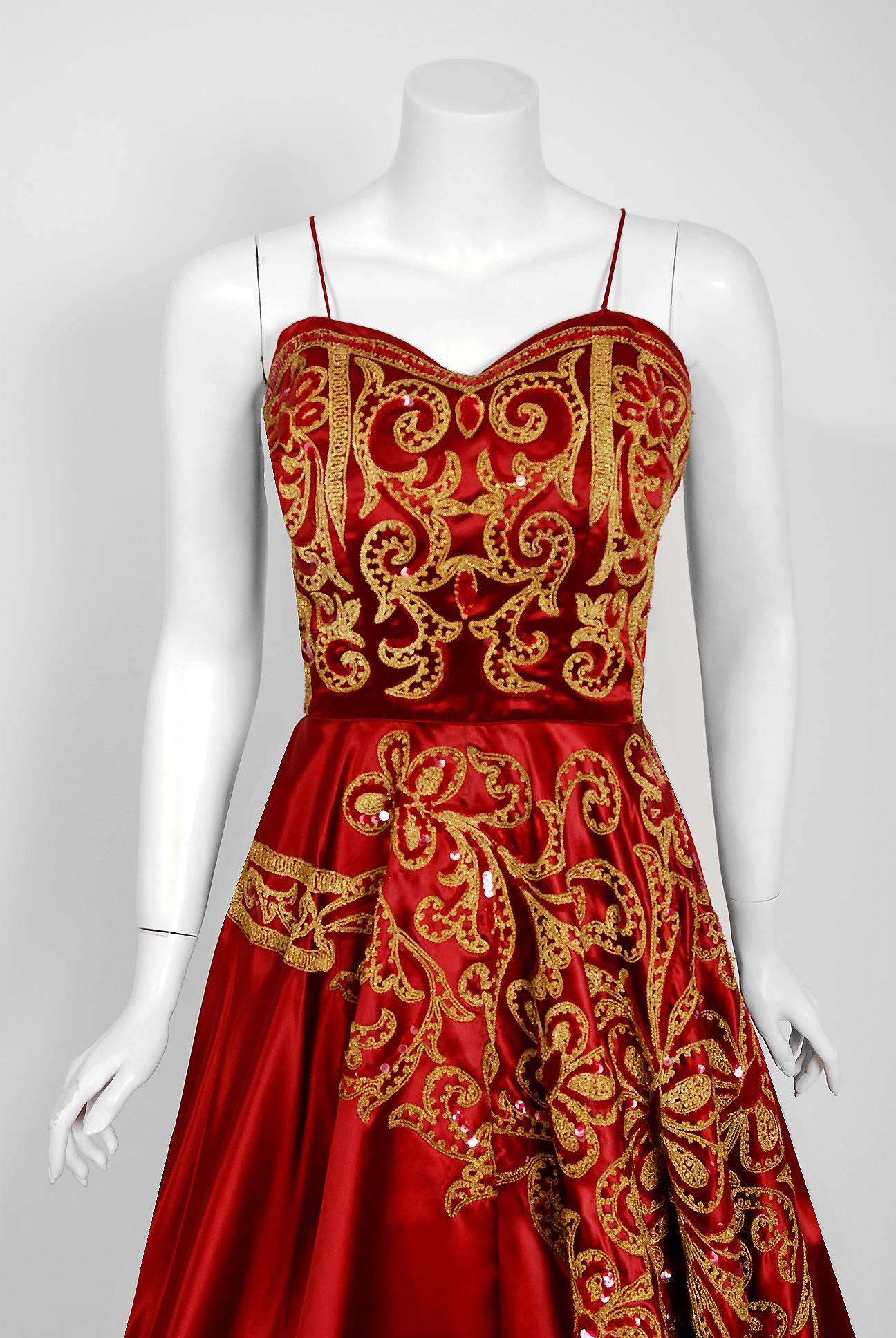 In this gorgeous 1950's Judith Lynn wine-red satin party dress, the detailed construction and meticulous attention to detail are comparable to what you will find in modern couture. This enchanting garment is fashioned from metallic embroidered,