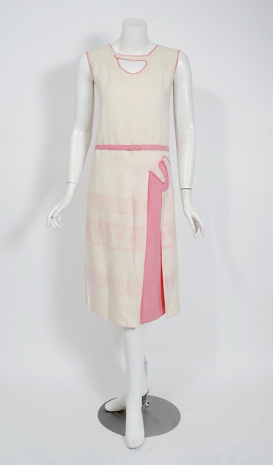 Incredibly unique 1920's pink and ivory linen sundress with a captivating dancing ladies novelty print! I love encountering new kitschy patterns in antique garments and this deco dress is constructed with alluring details as well. The sleeveless