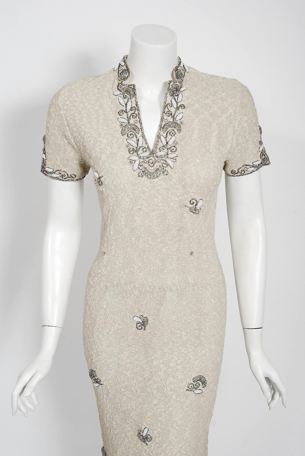 This is an incredible late 1940's hand-knit metallic cocktail that is also covered with sparkling floral-motif beadwork. The wool knit has a way of hugging the body that is infinitely flattering. The bodice is an elegant high-neck plunge and elegant