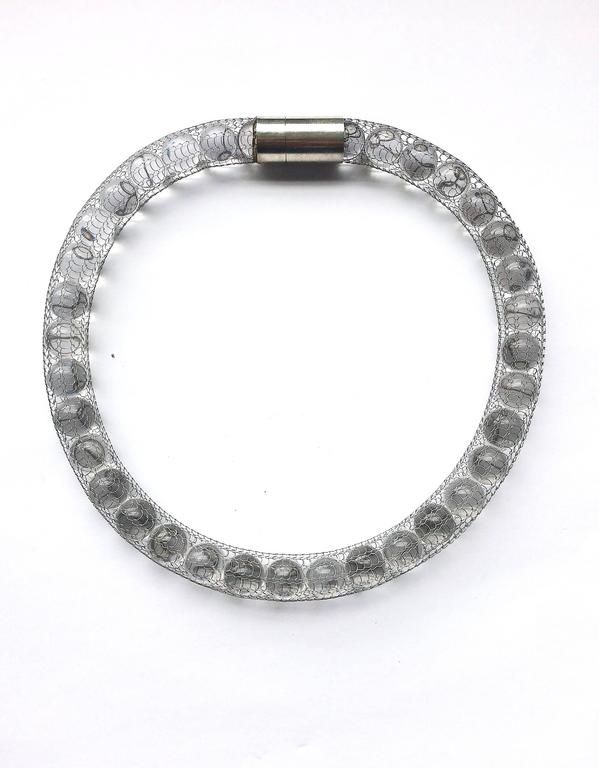 A highly original and stylish single row necklace or torque style collar, made from clear resin 'pearls' , encased in a fine very flexible stainless steel mesh, with a hallmarked sterling silver magnetic clasp, unique to the WW Collection, a