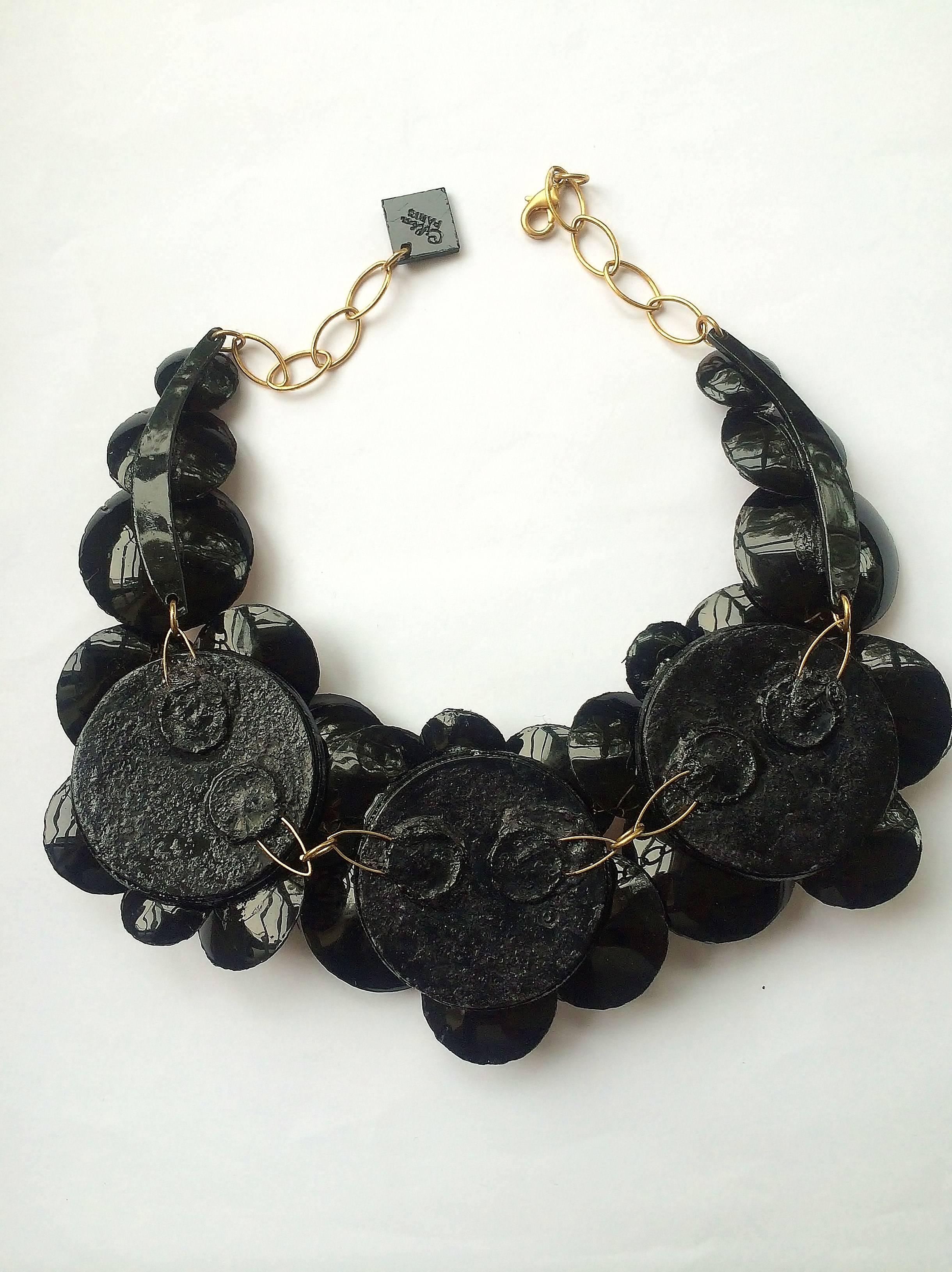 Light and easy to wear, this handmade artisanal necklace was made in Paris by Cilea. Concave black resin discs embellished with metallic bronze leaf, clustered together to form a powerful statement piece.
A wonderful winter necklace, looks great