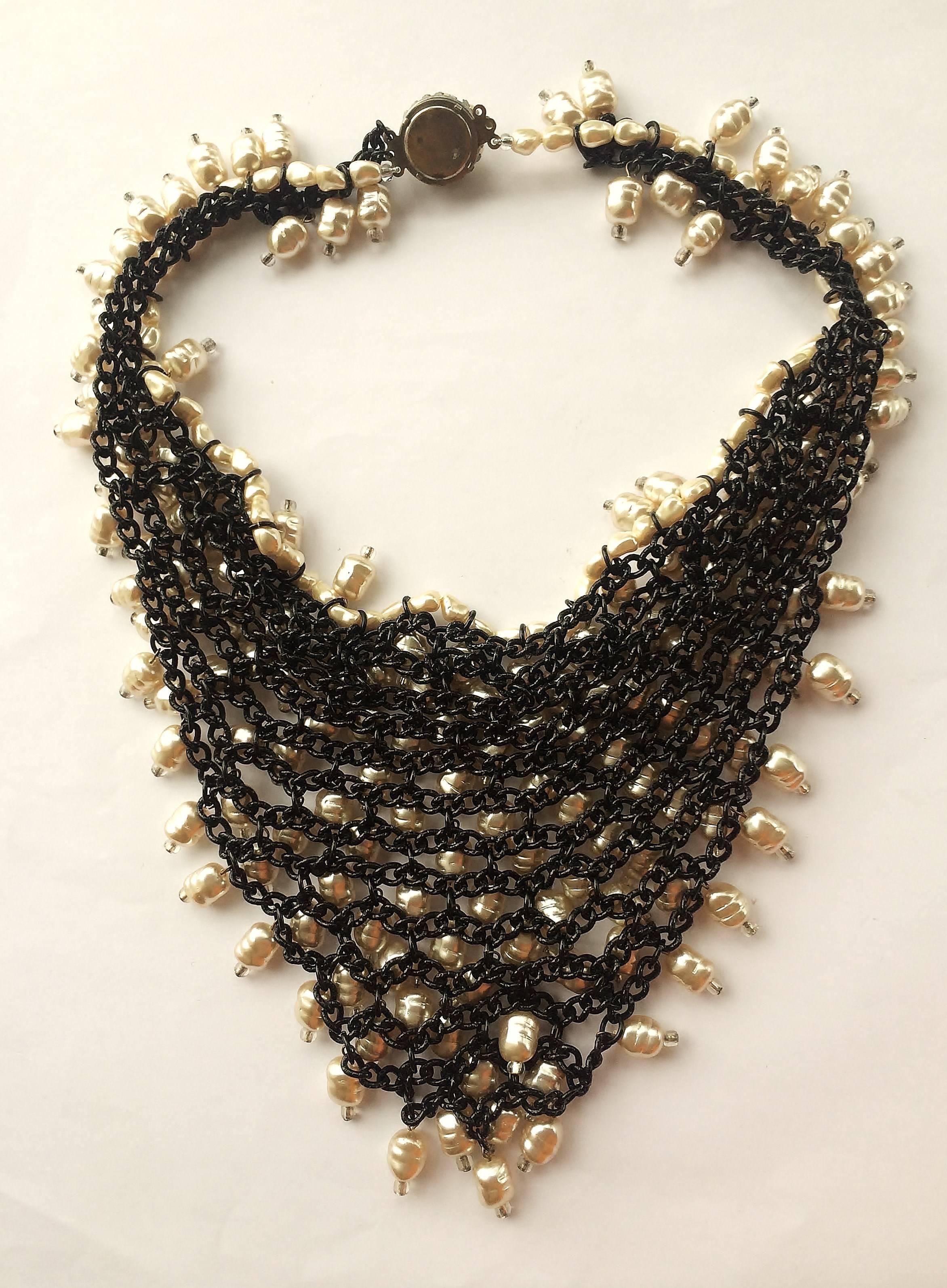 Highly striking and unusual glass baroque pearl 'bib' necklace, each pearl having a crystal bead at the end. The whole necklace is set on black metal or 'japanned' chain mail.
This is an unsigned necklace, maker unknown.
