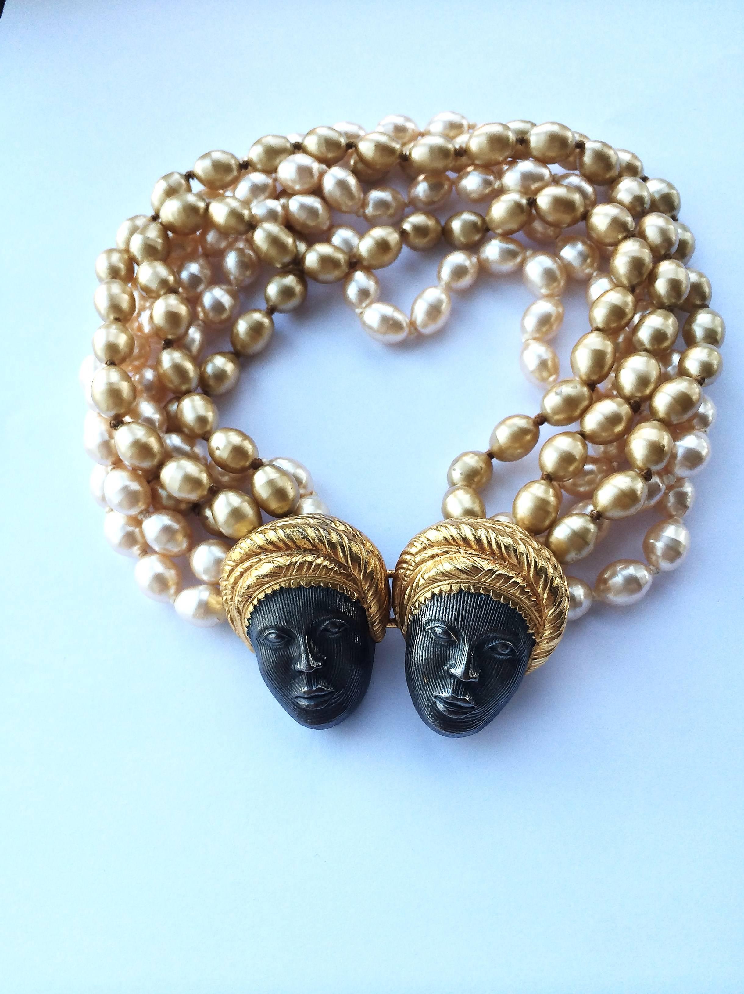 Bold and stylised multi row coloured baroque pearl necklace, with gilt and blackened metal clasp in the form of two tribal faces, by Isabel Canovas, from the 1980s. Highly typical of her output, this chic pearl statement piece can be worn with the