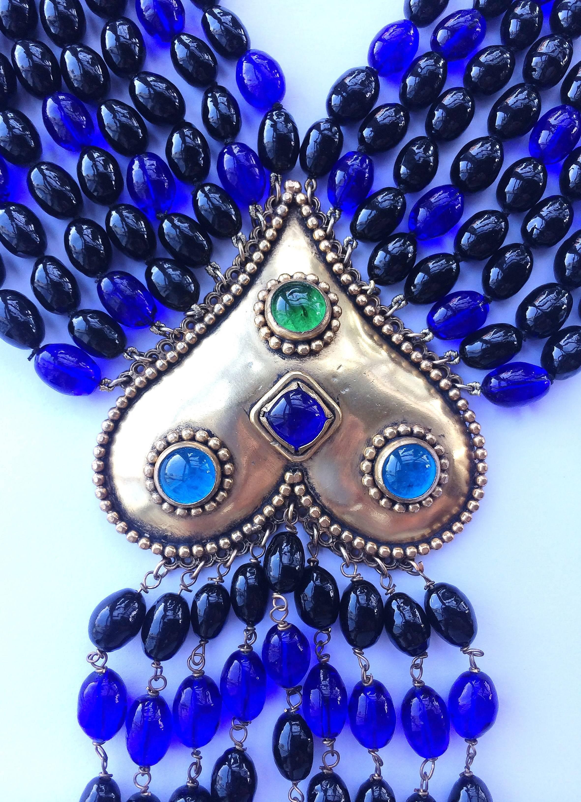 Opulent and magnificent blue and black poured glass sautoir style necklace, with large gilt and jewelled 'heart' centrepiece, by Isabel Canovas from the 1980s. Aqua,sapphire and peridot poured glass stones adorn the burnished gilt heart , which is