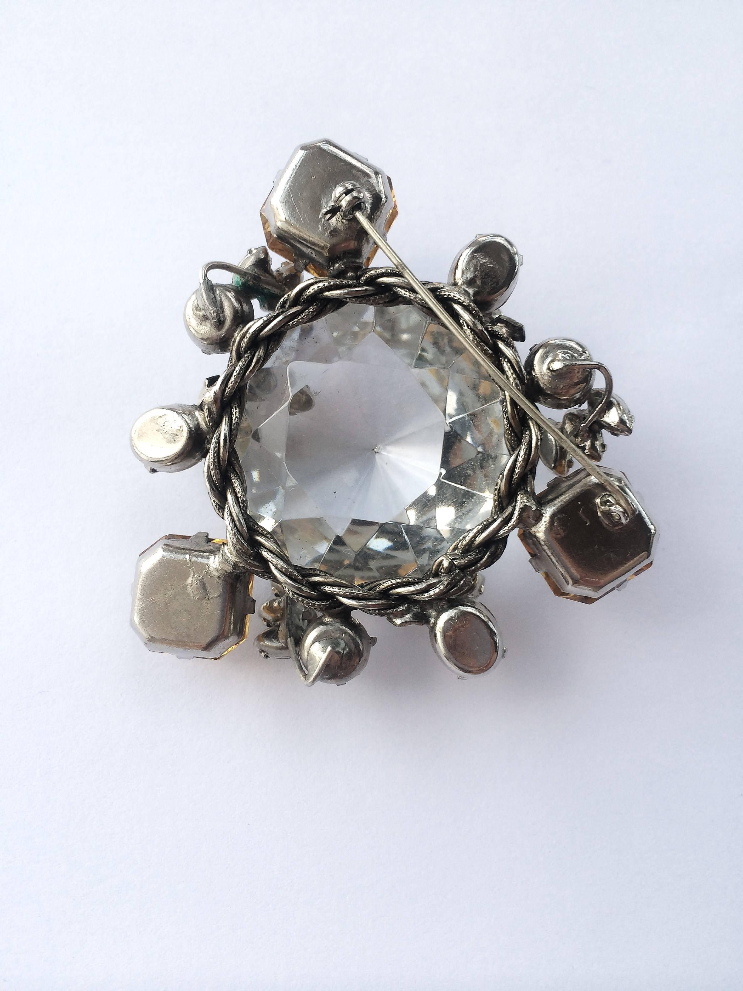 This beautiful brooch with a large clear central stone, surrounded by sapphire, smokey quartz and topaz pastes of assorted shapes, and pearl highlights, is a very typical Schreiner piece, though it is unsigned.
Henry Schreiner started the Schreiner