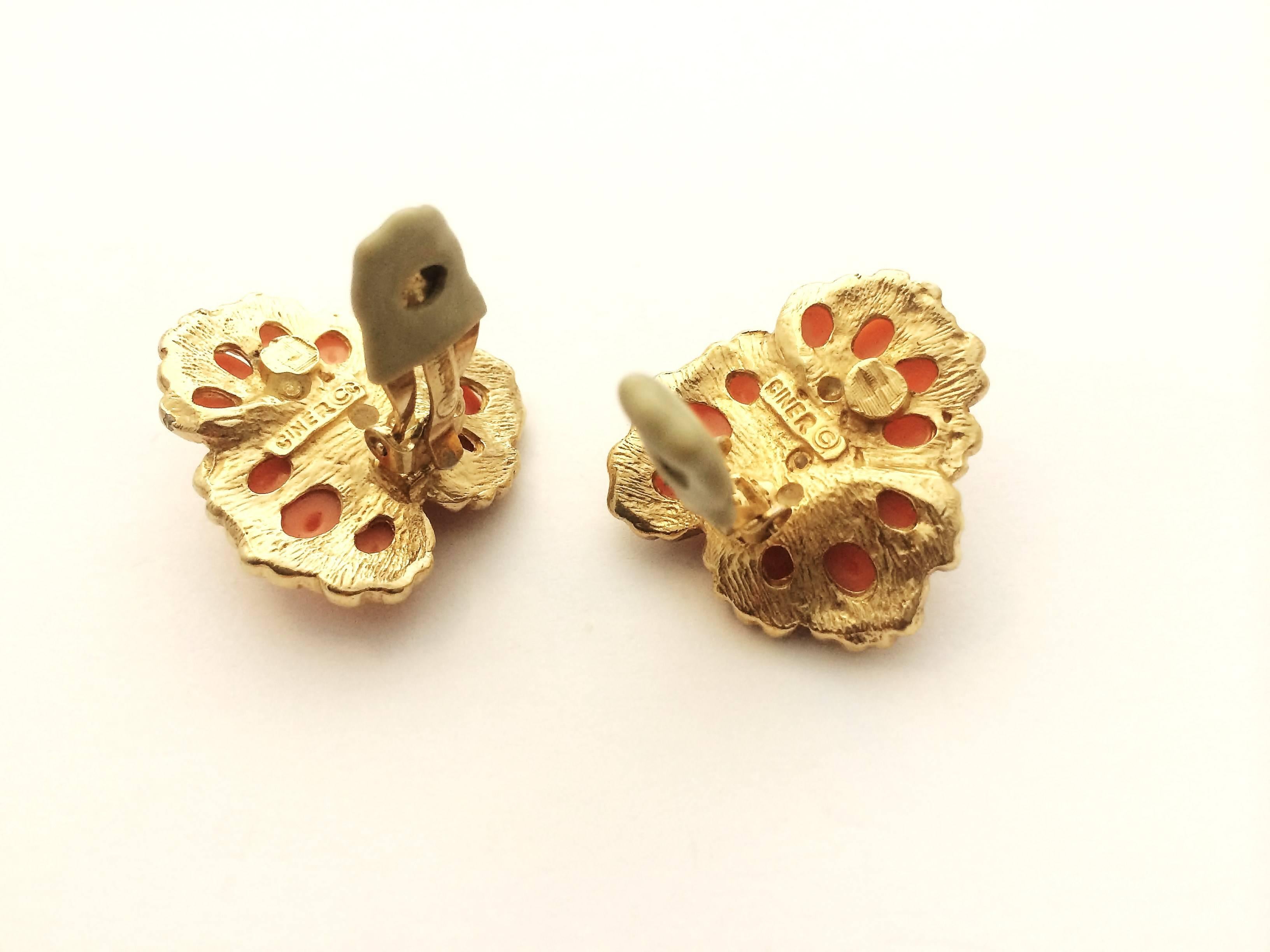 These earrings are made of soft coral cabochon and clear pastes, set in gilt metal, made in a stylised 'floral motif, typical of the glamour and scale of the 1980s. These earrings are from the estate of Deborah, Duchess of Devonshire, one of the