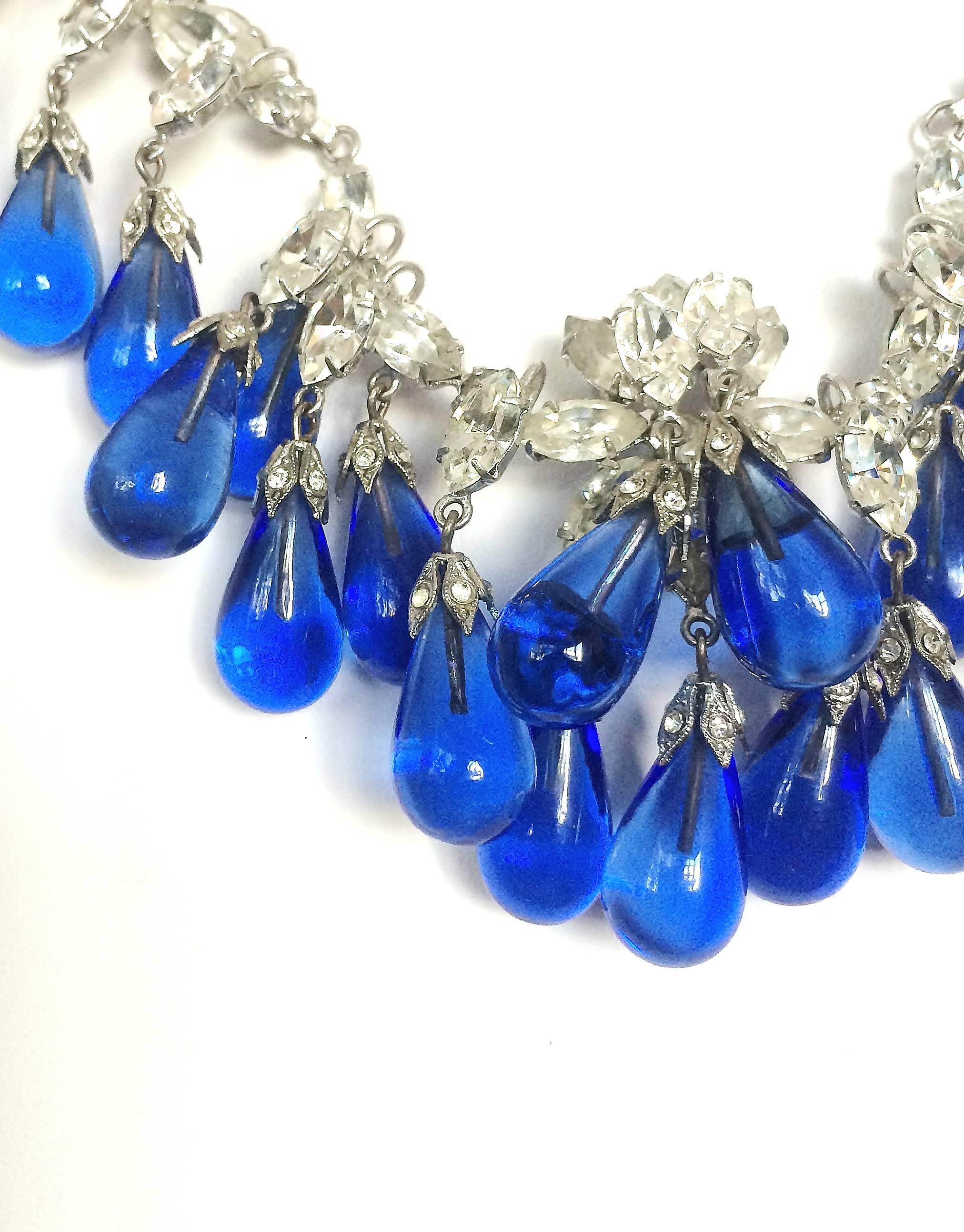 Sumptuous and glamorous, this beautiful necklace is made of poured glass sapphire drops, the main part being set with clear pastes. Each sapphire drop is topped with a jewelled cap. Bearing all the qualities of both a Scemama creation and Dior