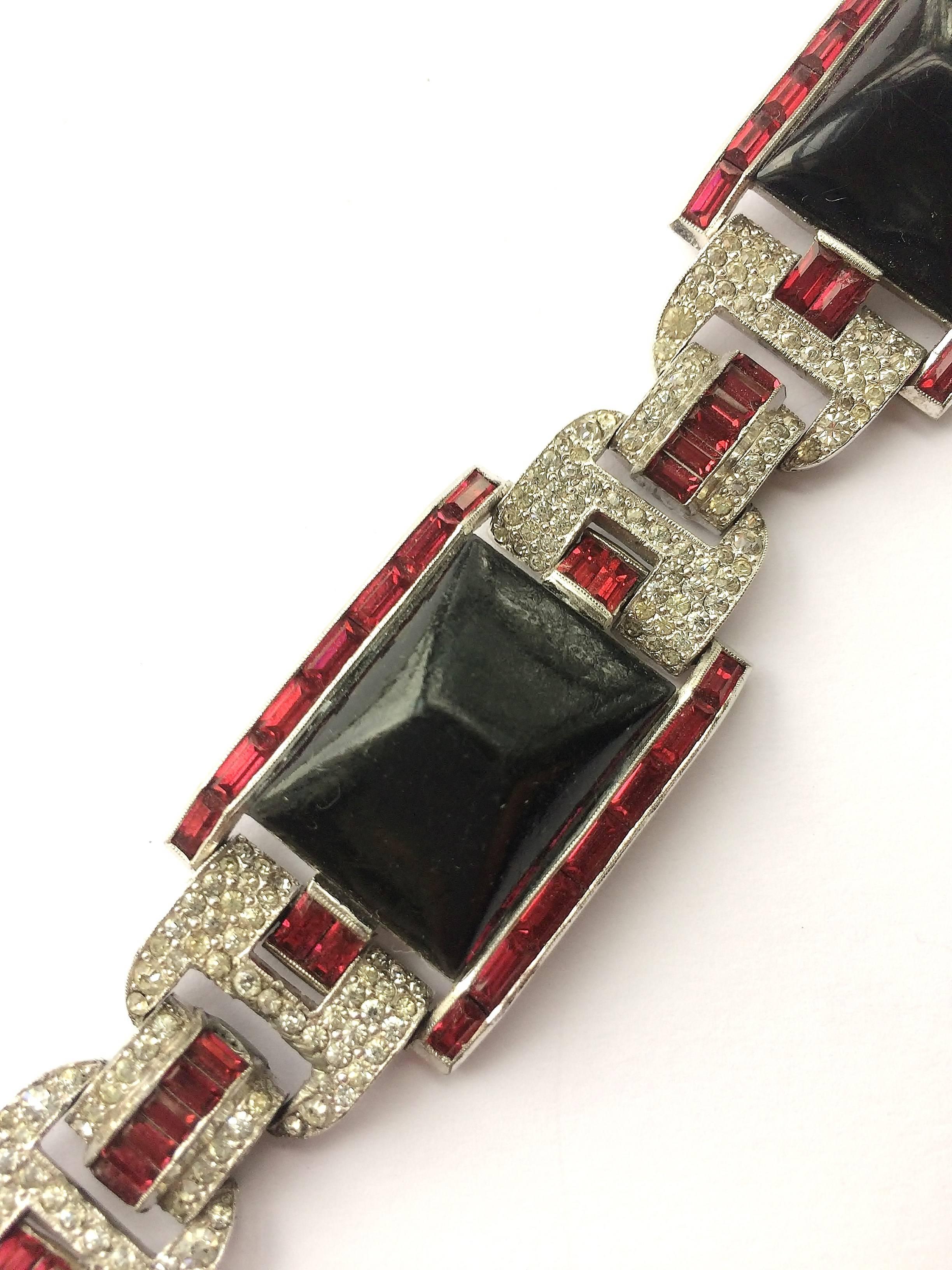 This wonderful bracelet by Trifari (marked KTF as shown) is high high Deco, a design never seen before in Trifari's designs.. Made from three enamelled pressed metal relief panels, and highlighted with ruby and clear pastes,all set in rhodium metal,